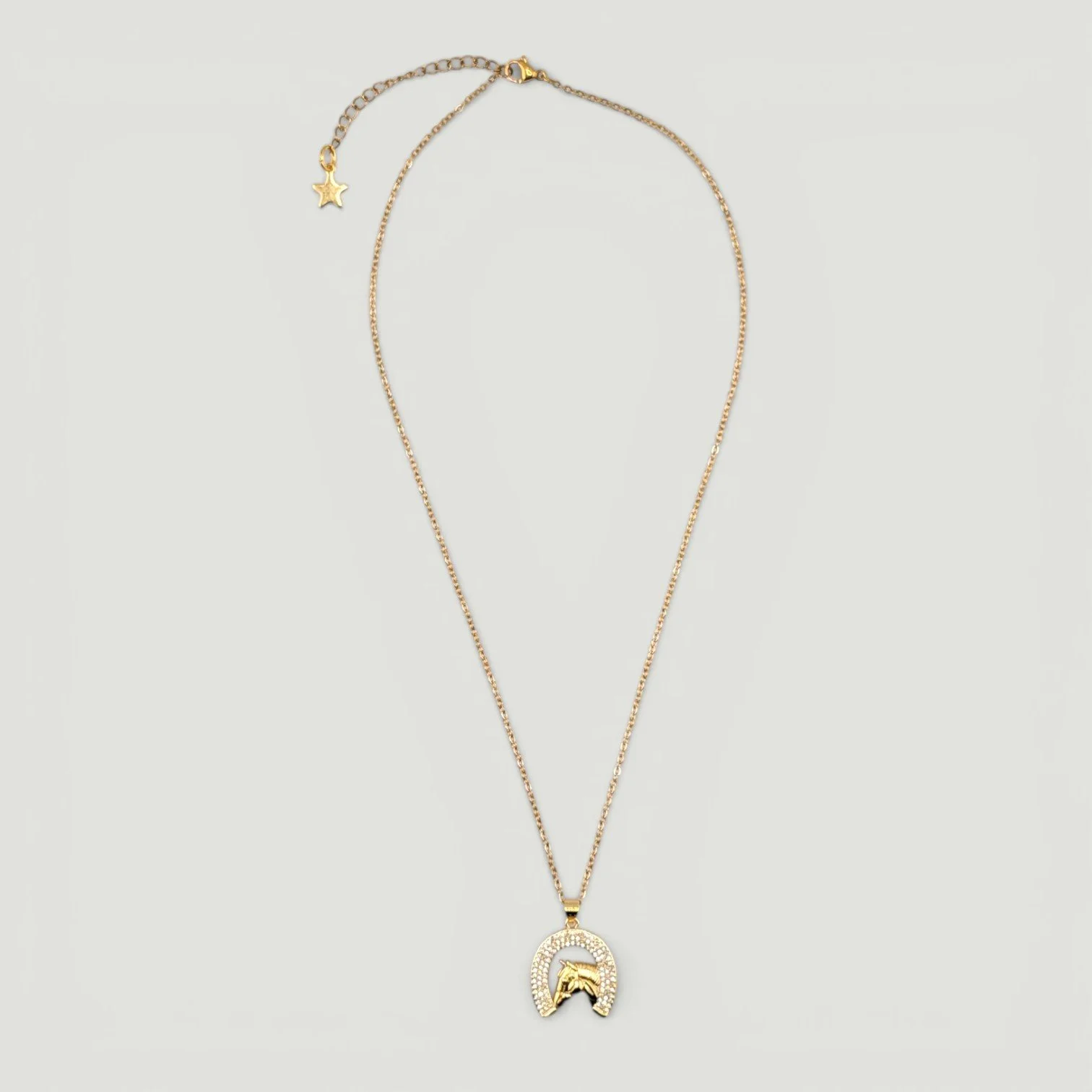 Rhinestone horseshoe horse gold stainless steel necklace, full view flat lay