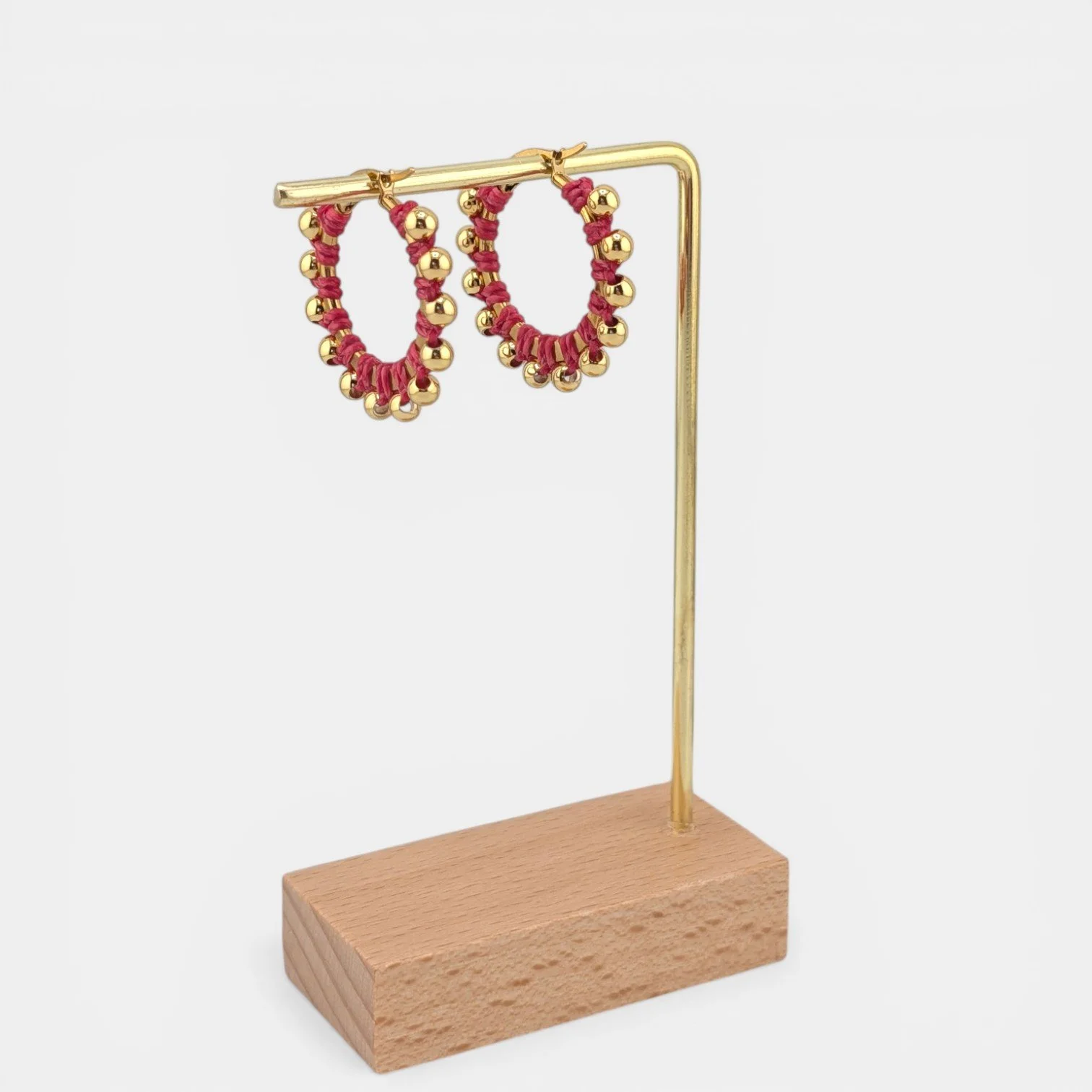 Pink beaded macramé stainless steel hoop earrings in gold, 30 mm drop shown on earring display stand