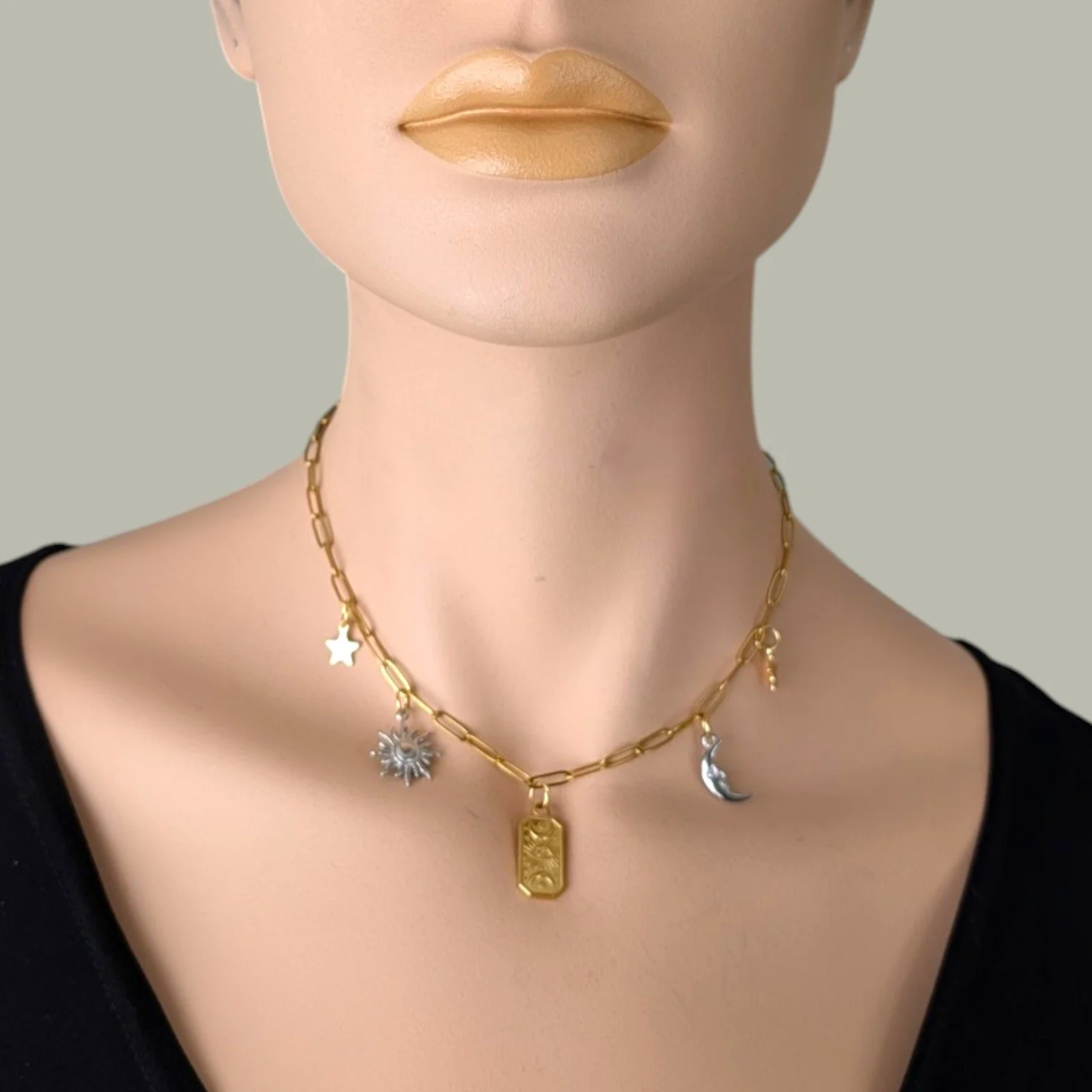 Gold two-tone evil eye celestial stainless steel charm necklace on mannequin, close up bust view.
