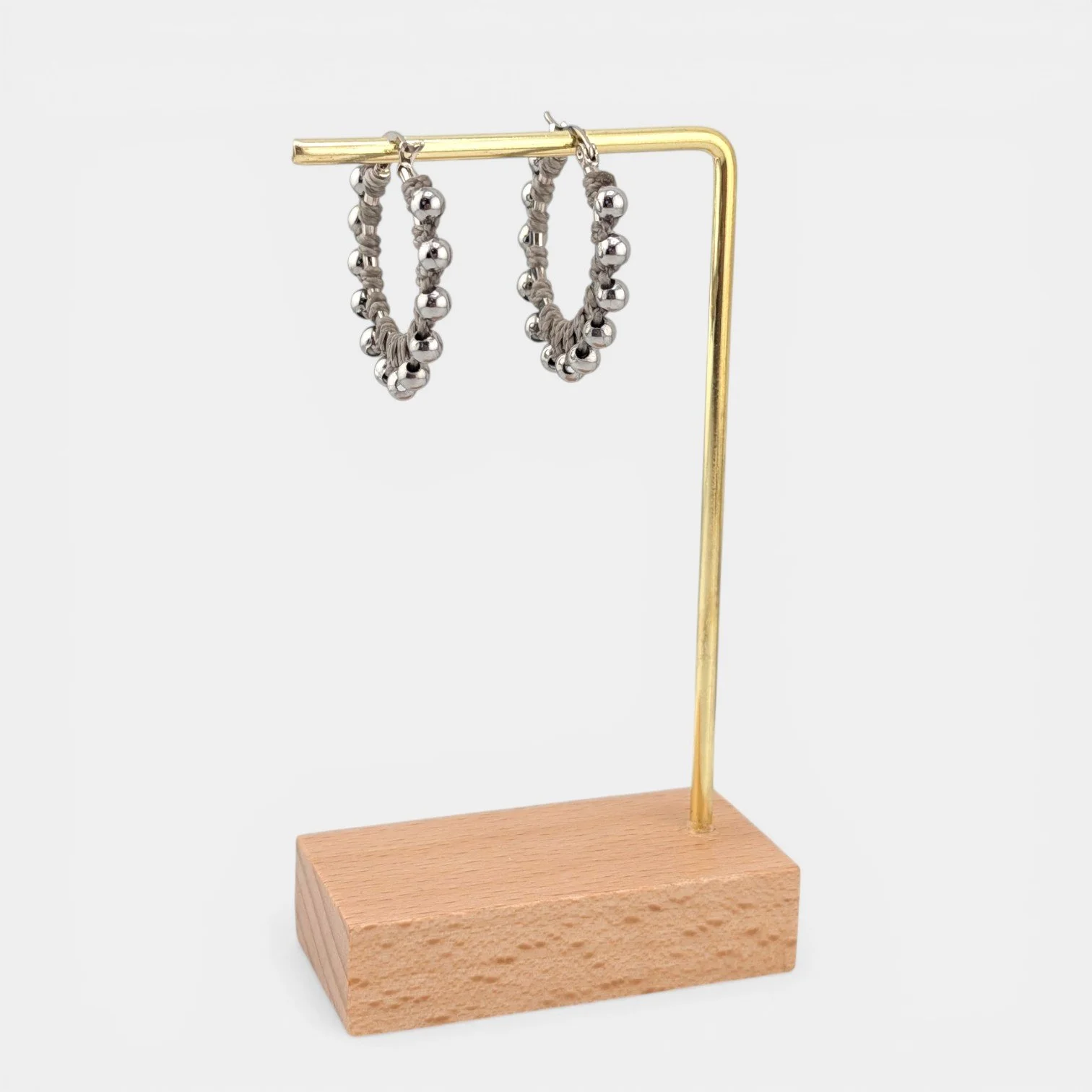 light gray beaded macramé stainless steel hoop earrings in silver, 30 mm drop shown on earring display stand