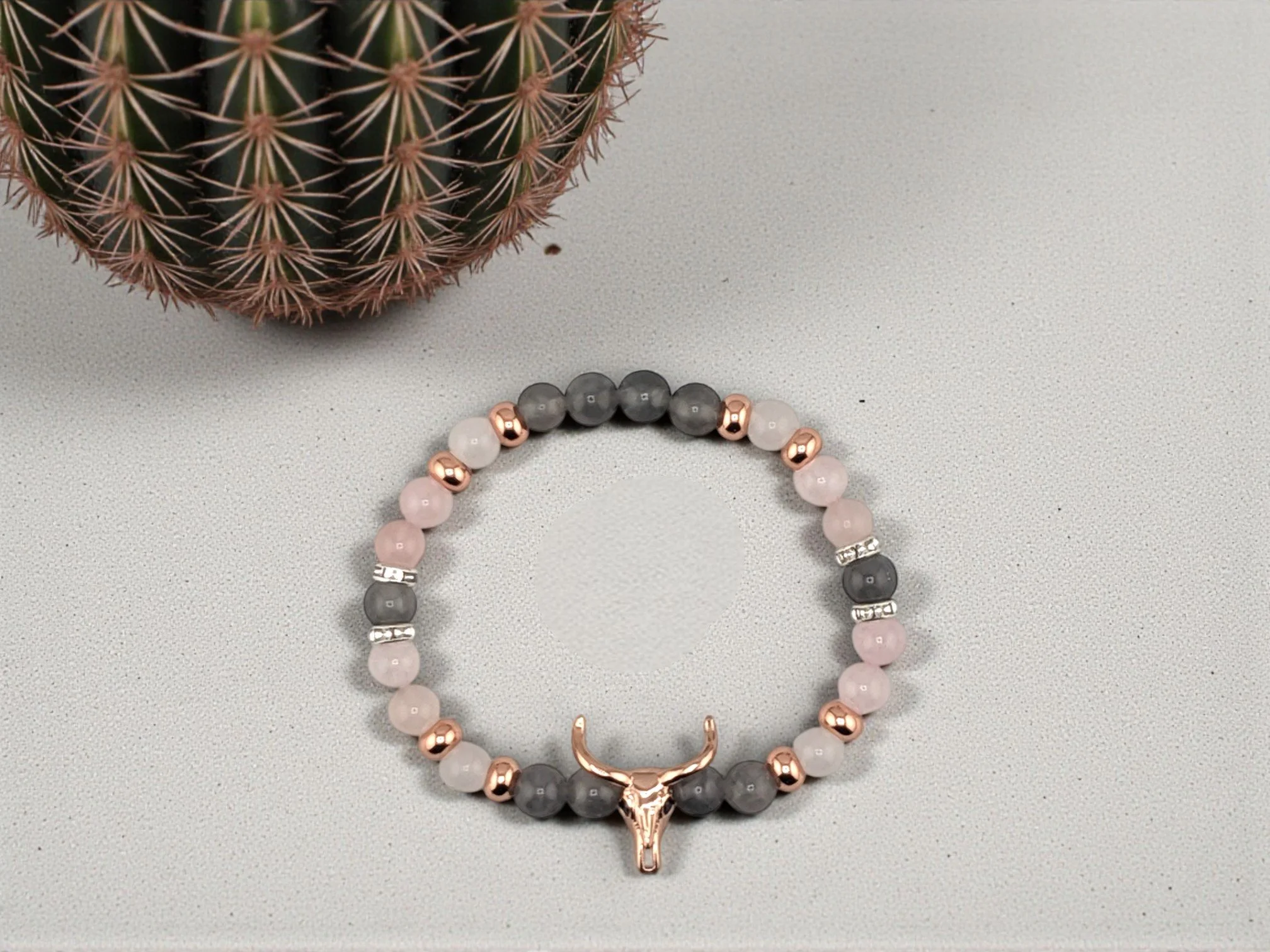 Dainty rose gold color bull skull beaded bracelet with rose quartz and cloudy quartz separated by rose gold colored spacer beads
