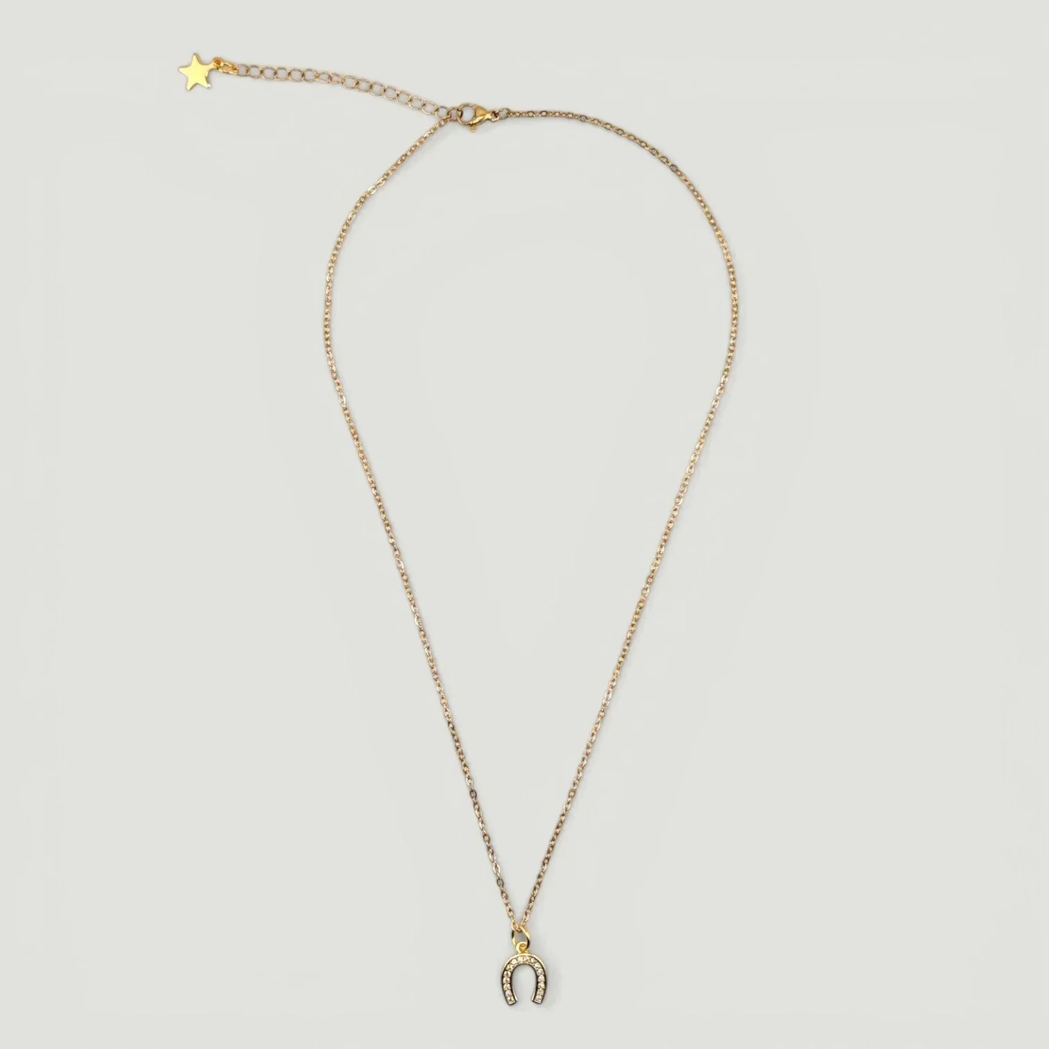 gold rhinestone horseshoe necklace on stainless steel chain, full flat lay
