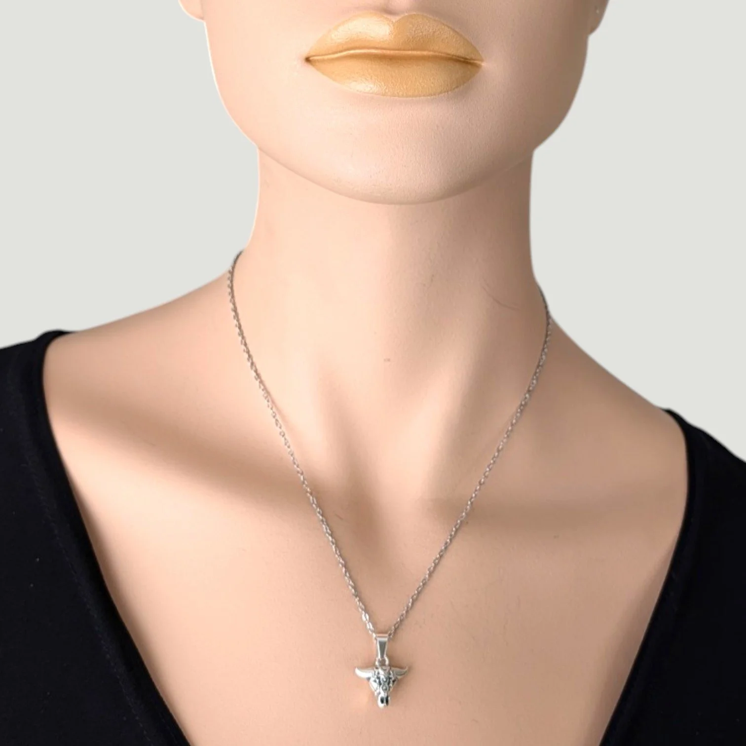 bull skull pendant on a silver stainless steel chain worn on mannequin, close up bust view