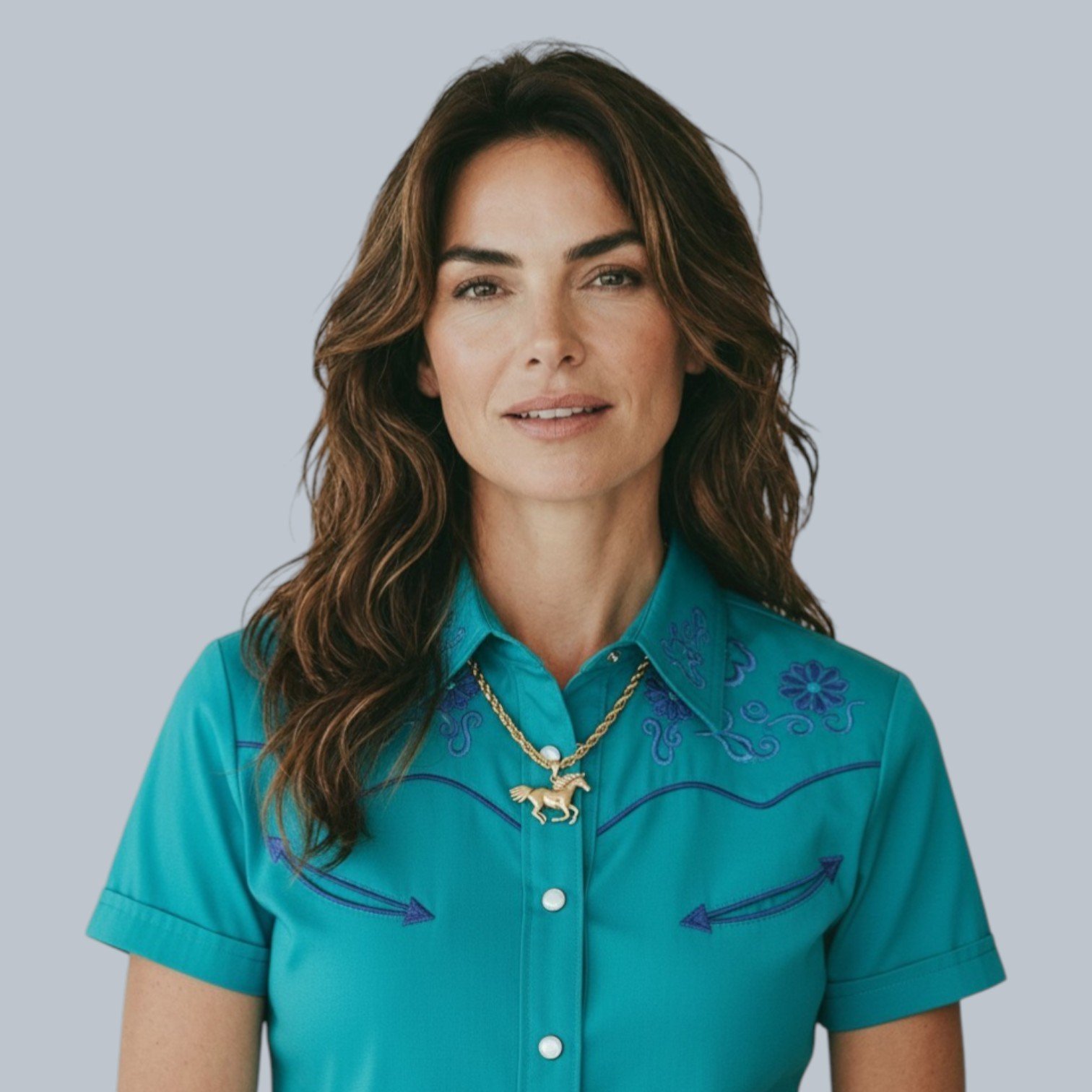 chunky horse gold stainless steel statement necklace on brunette model wearing a turquoise western shirt