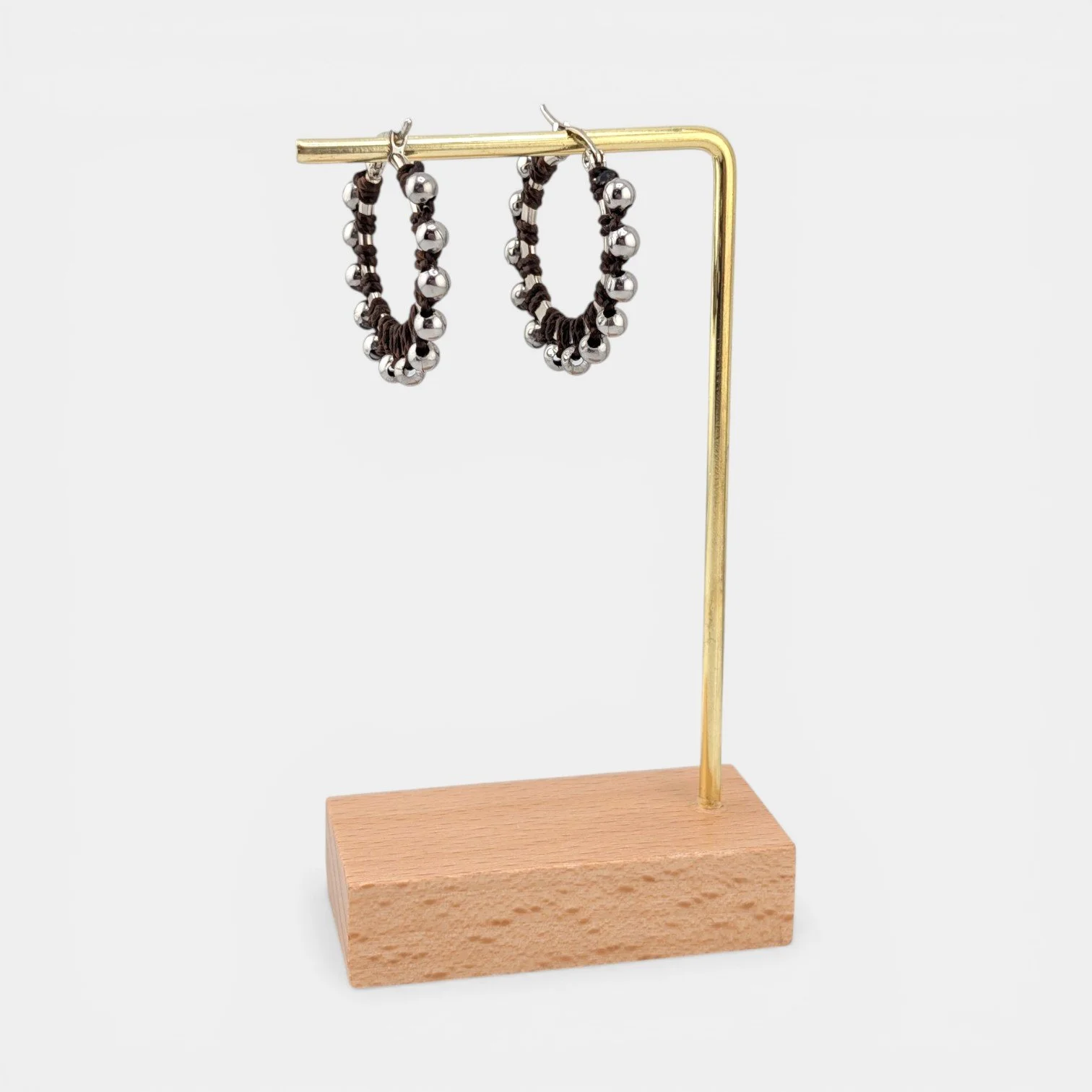 Dark brown beaded macramé stainless steel hoop earrings in silver, 30 mm drop shown on earring display stand