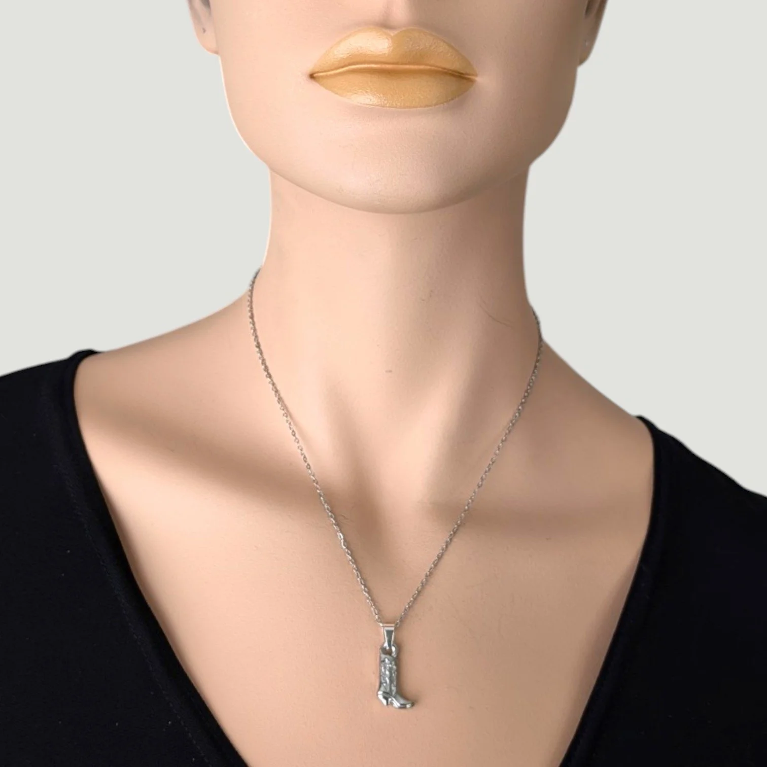 Silver stainless steel cowboy boot necklace on mannequin, close up bust view