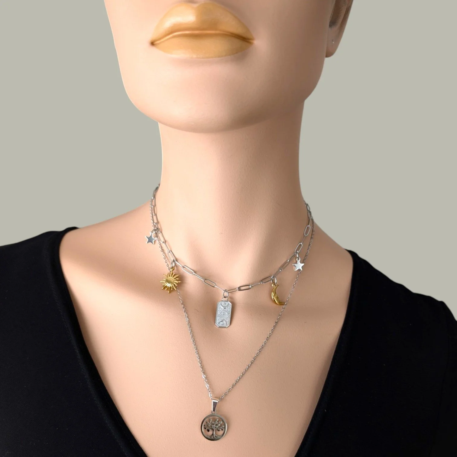 Silver Evil eye celestial stainless steel charm necklace layered with silver tree of life on mannequin, close up bust view