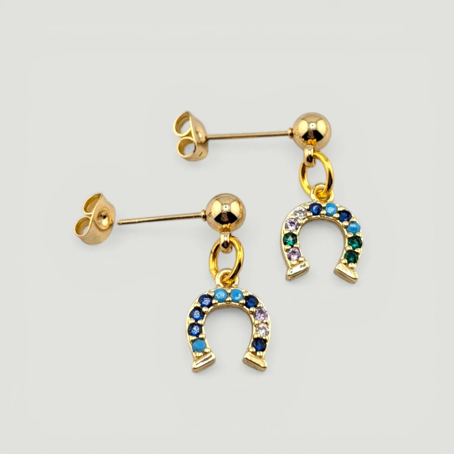 horseshoe stud drop earrings, gold tone, flat lay top view