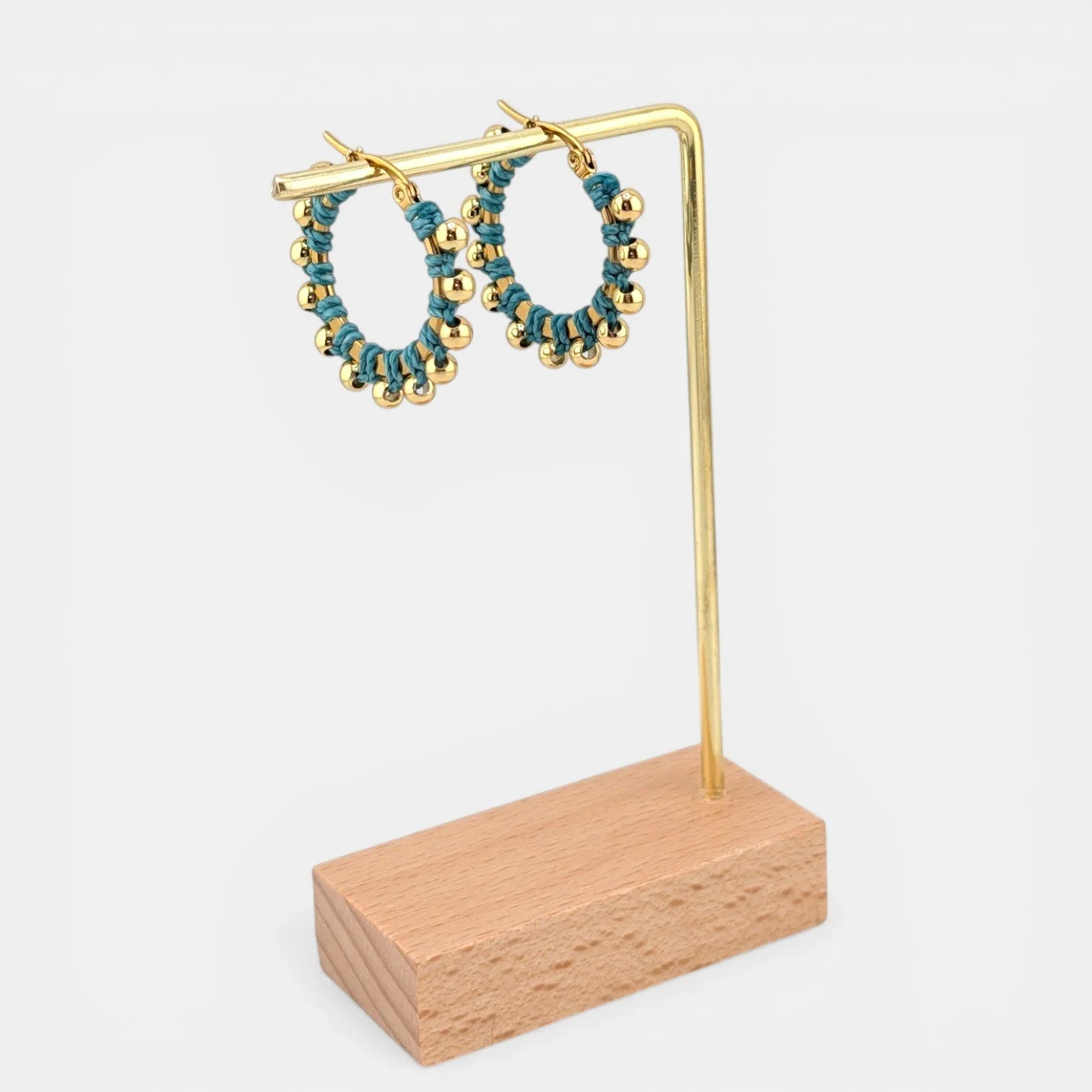Turquoise beaded macramé stainless steel hoop earrings in gold, 30 mm drop shown on earring display stand