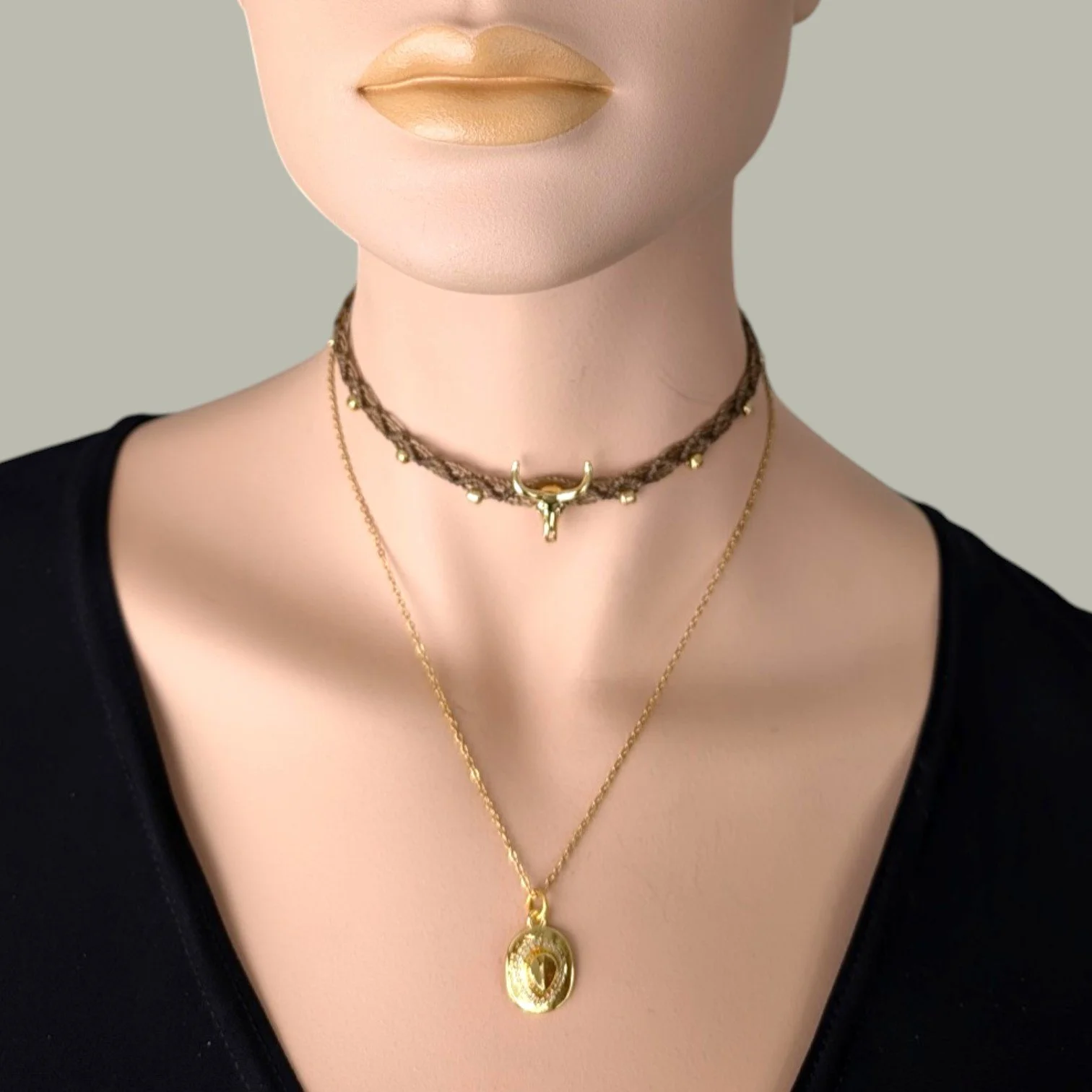 rhinestone cowboy hat necklace on a gold stainless steel chain layered with gull skull macrame choker on mannequin, close up bust view
