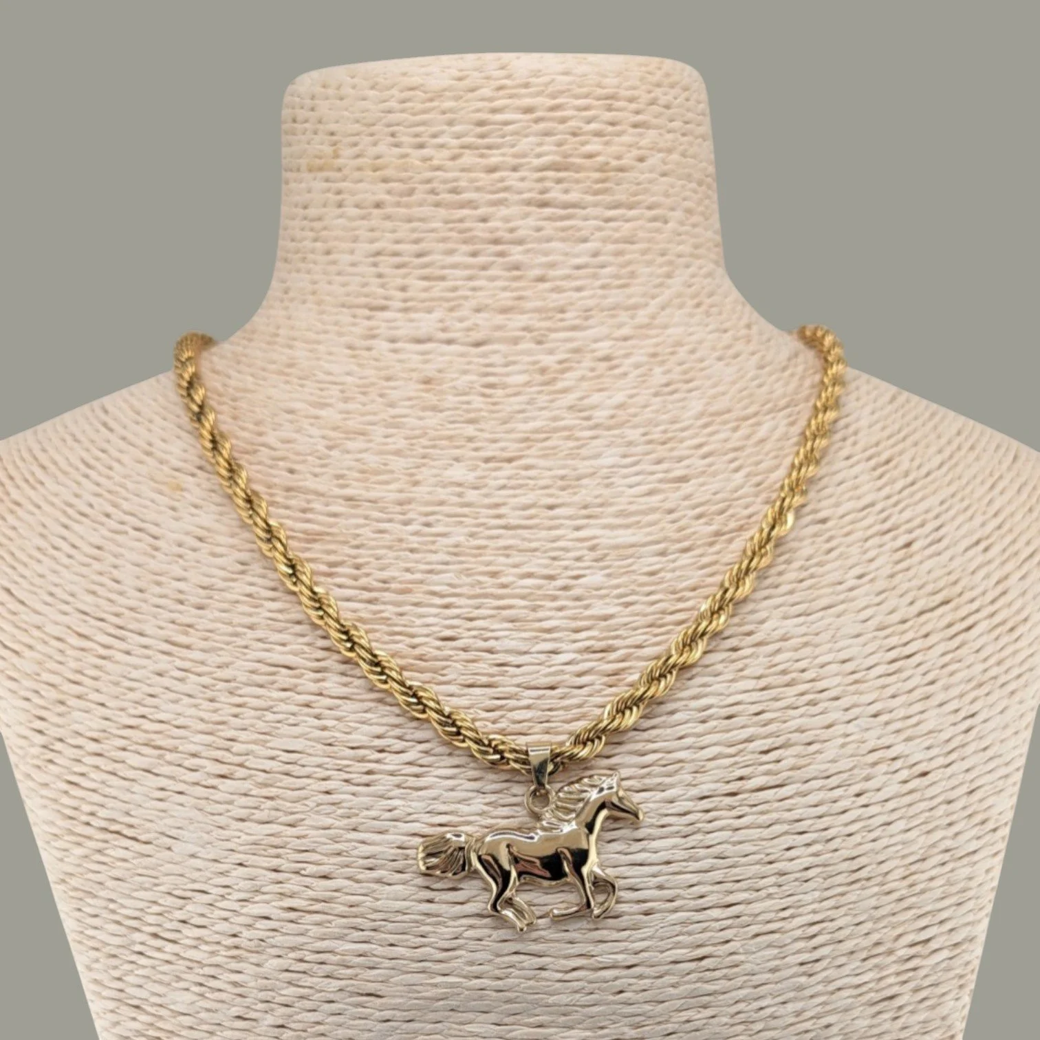 Chunky horse gold stainless steel necklace on rope bust close up view