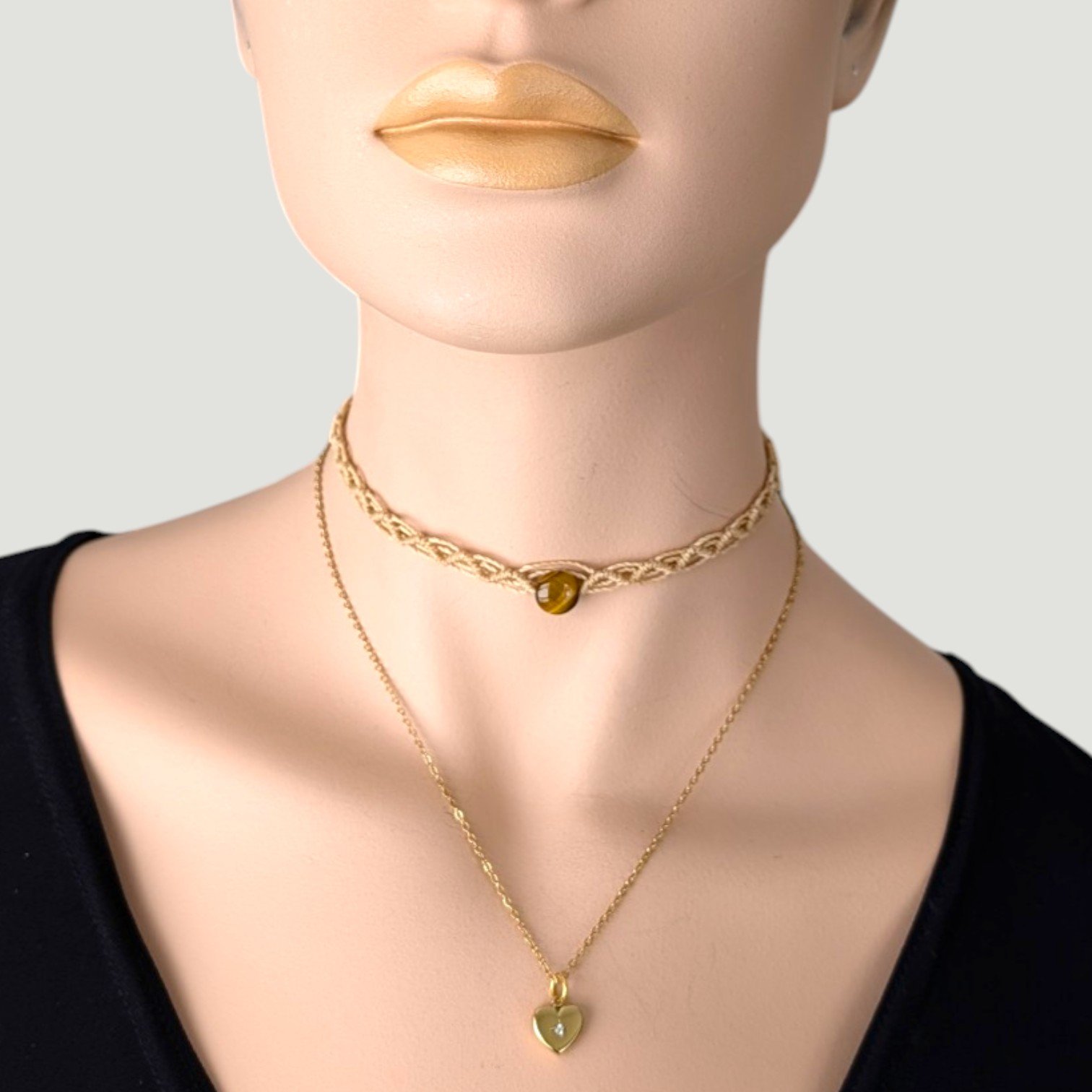 Gold stainless steel starburst heart necklace with tiger eye macrame choker on mannequin, bust view