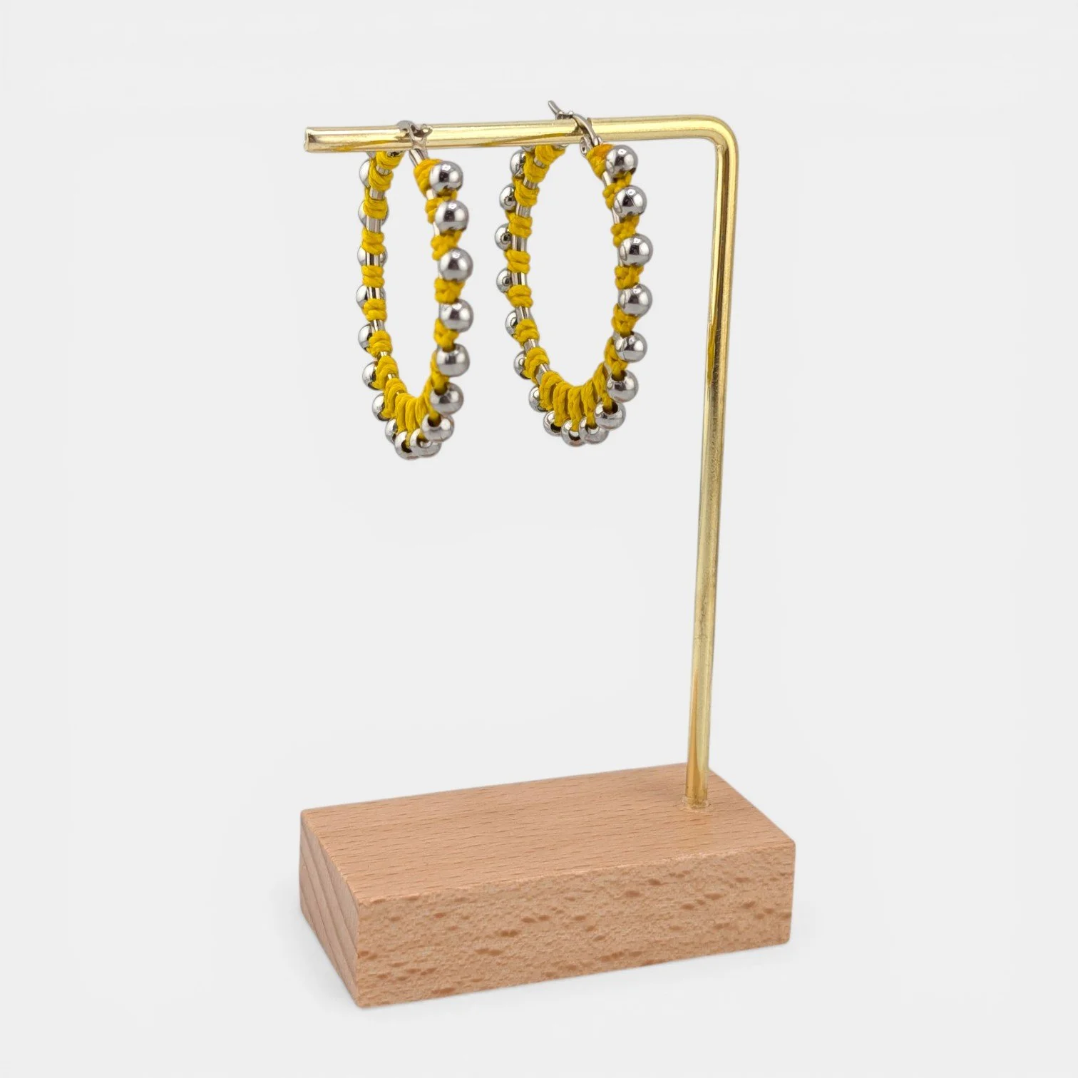 yellow beaded macramé stainless steel hoop earrings in silver, 40 mm drop shown on earring display stand