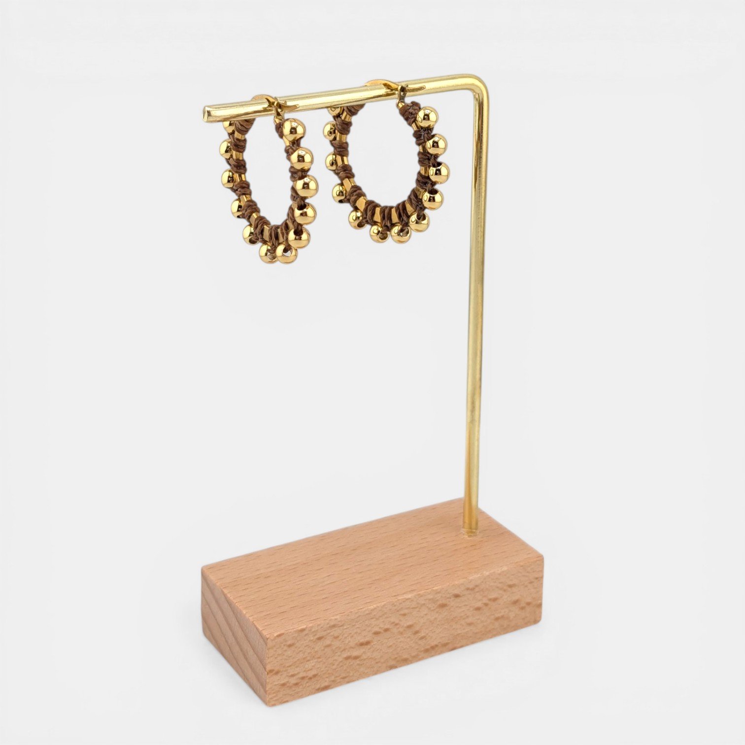 golden brown beaded macramé stainless steel hoop earrings in gold, 30 mm drop shown on earring display stand