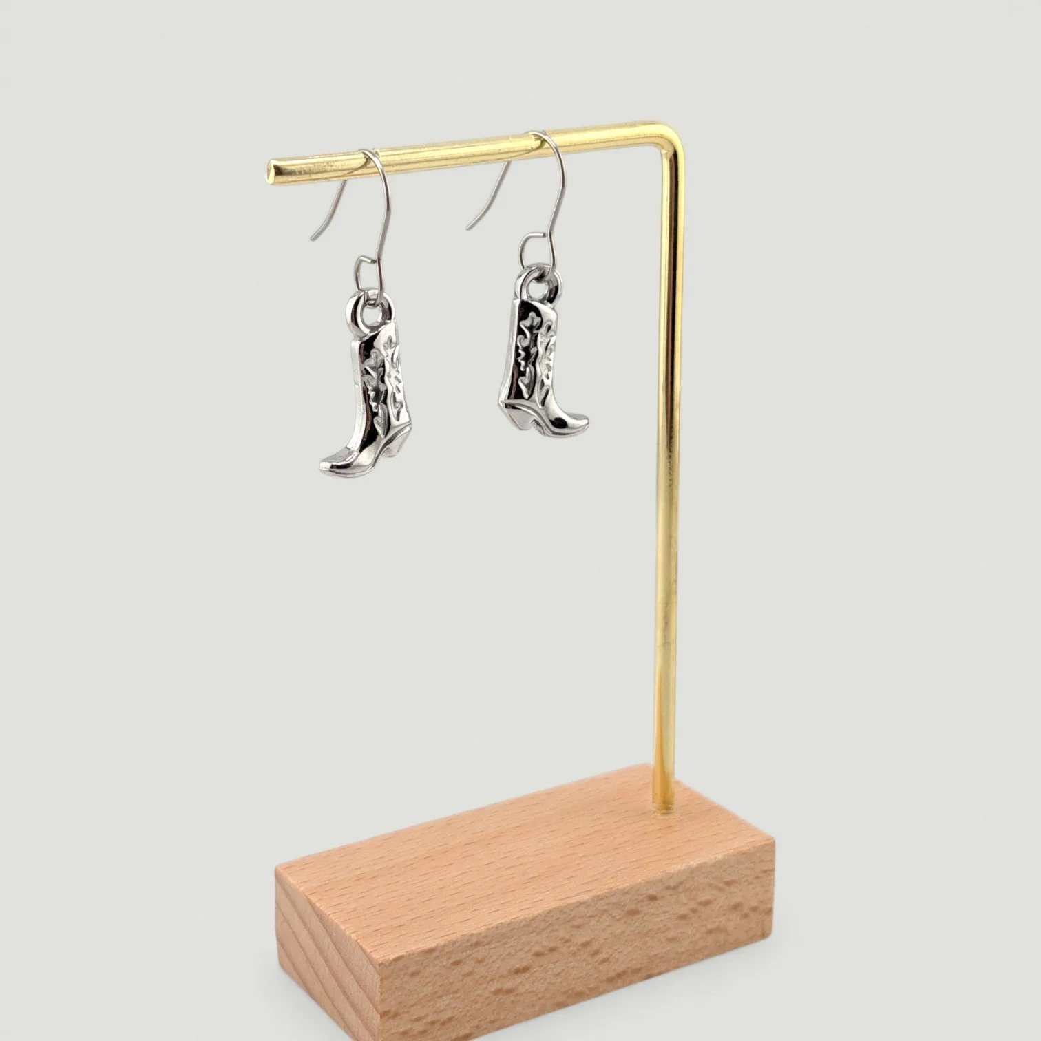 Silver cowboy boot drop earrings on display showing full length and movement