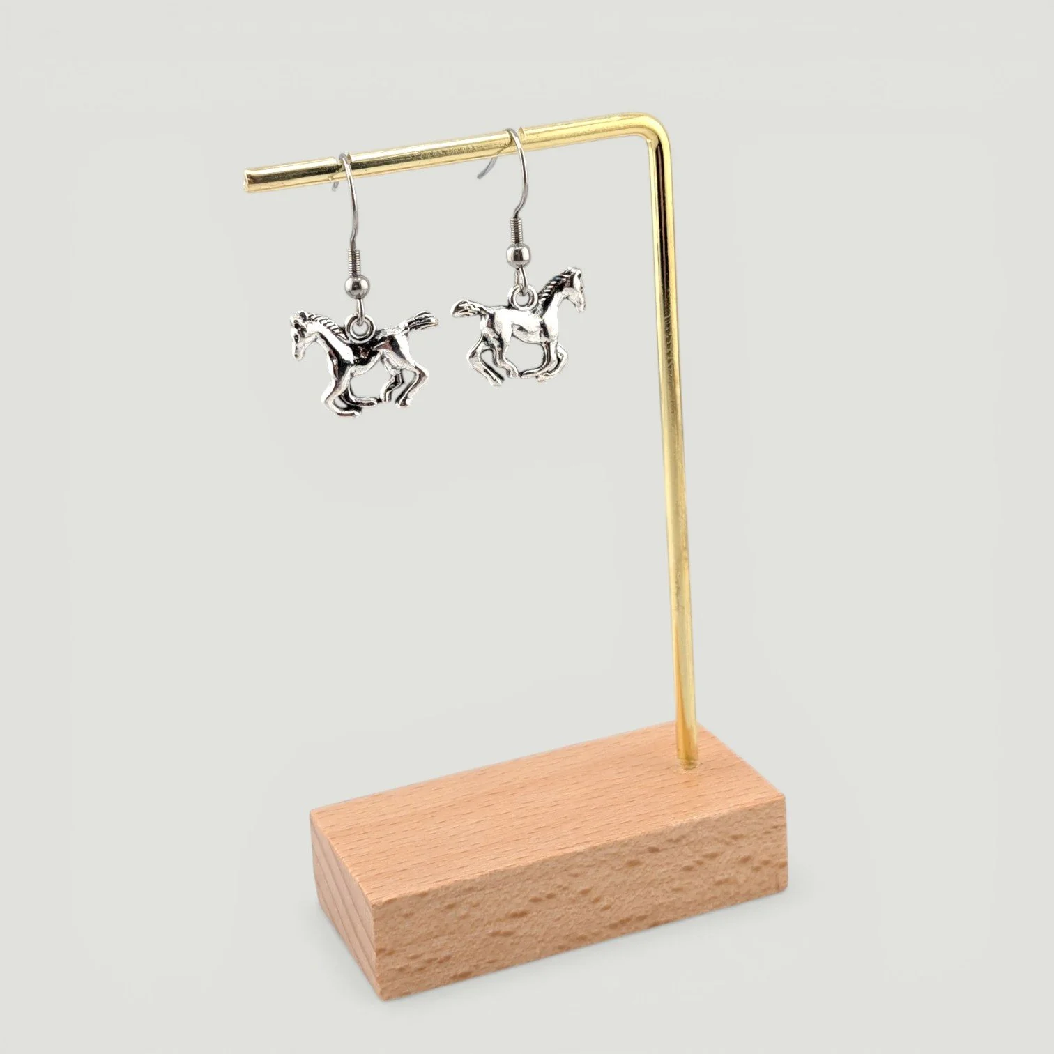 Galloping horse drop earrings, silver tone, hanging on earring stand, full drop view