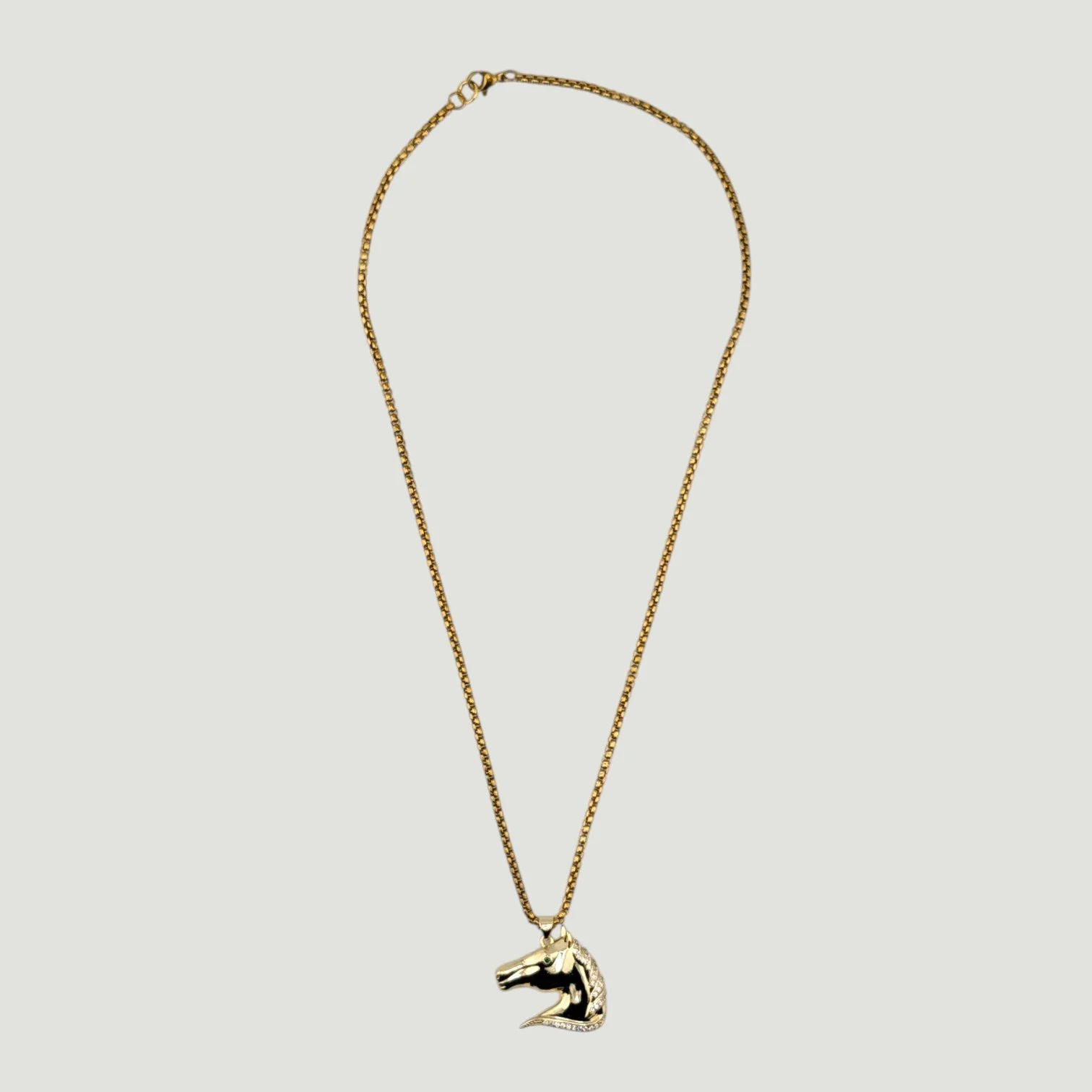 Rhinestone horse necklace on gold stainless steel chain, full view flat lay