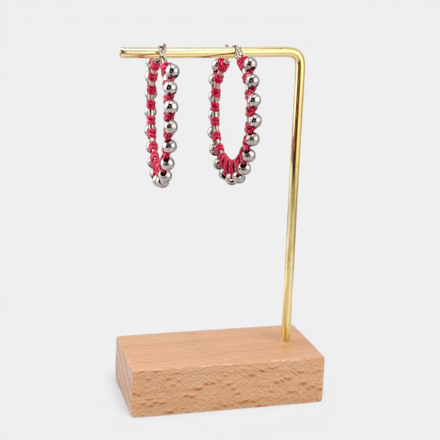 Pink beaded macramé stainless steel hoop earrings in silver, 40 mm drop shown on earring display stand