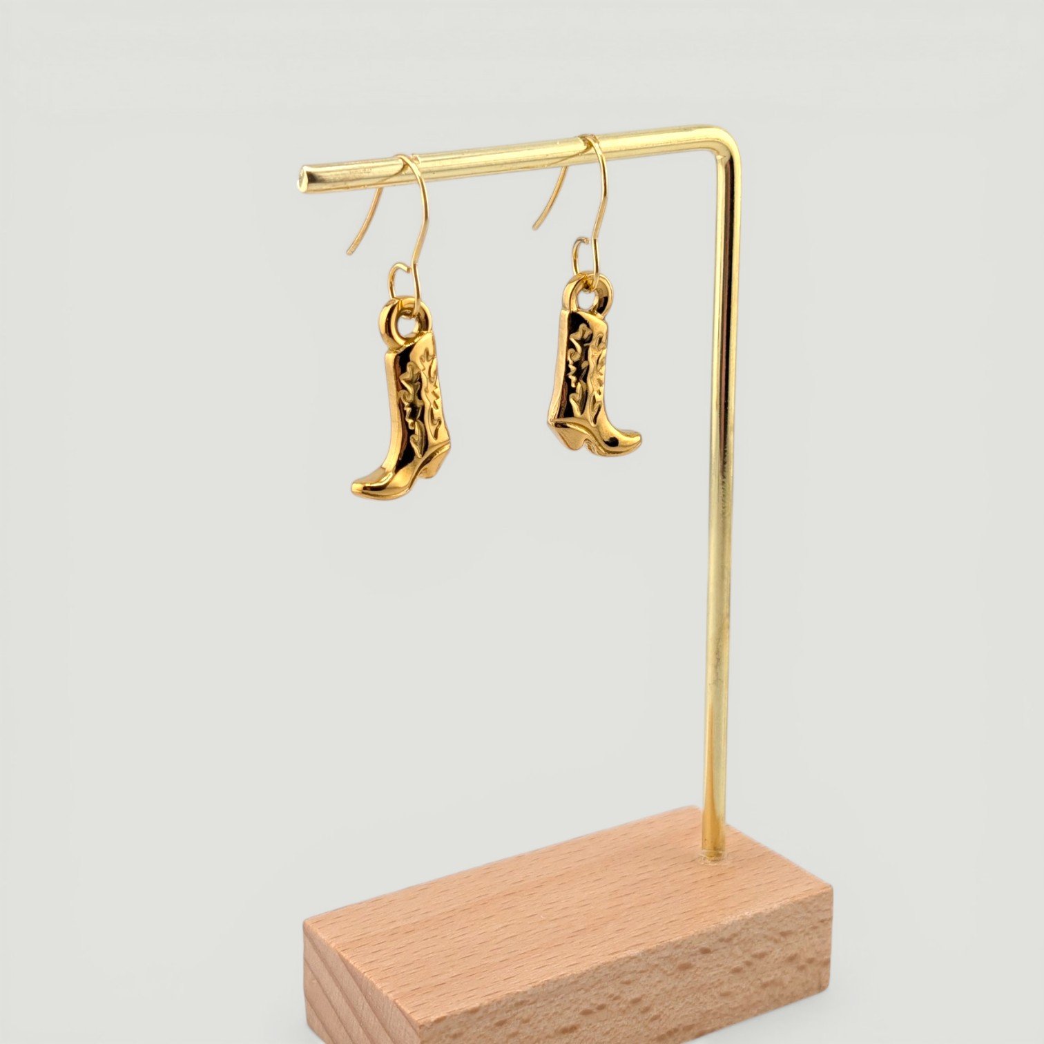Gold cowboy boot drop earrings on display showing full length and movement