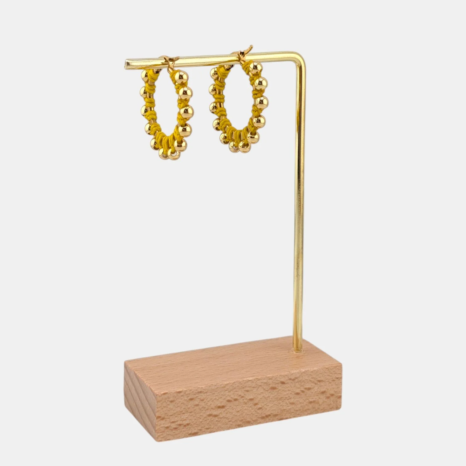 yellow beaded macramé stainless steel hoop earrings in gold, 30 mm drop shown on earring display stand