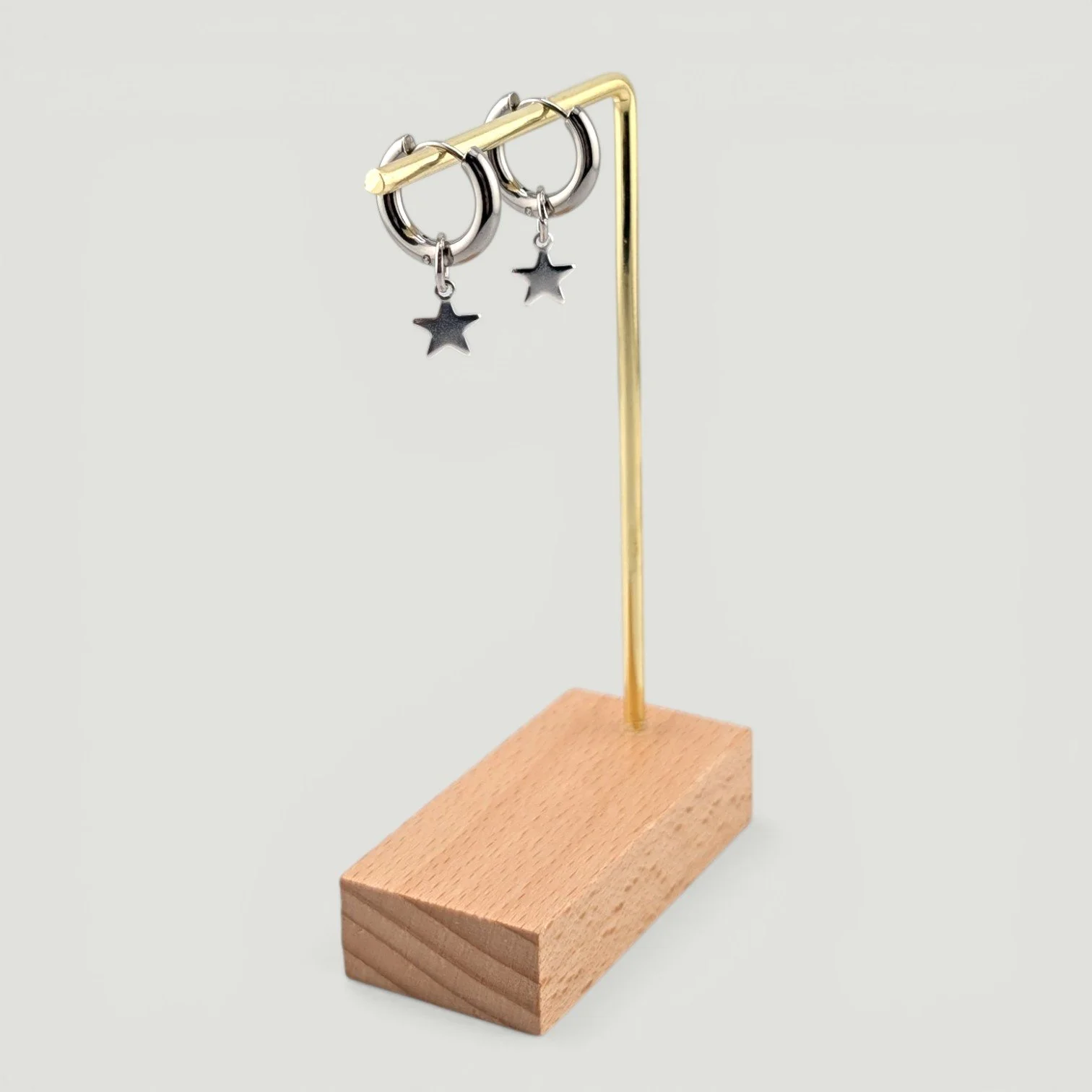 star stainless steel huggie hoop earrings, silver, on earring stand, drop view