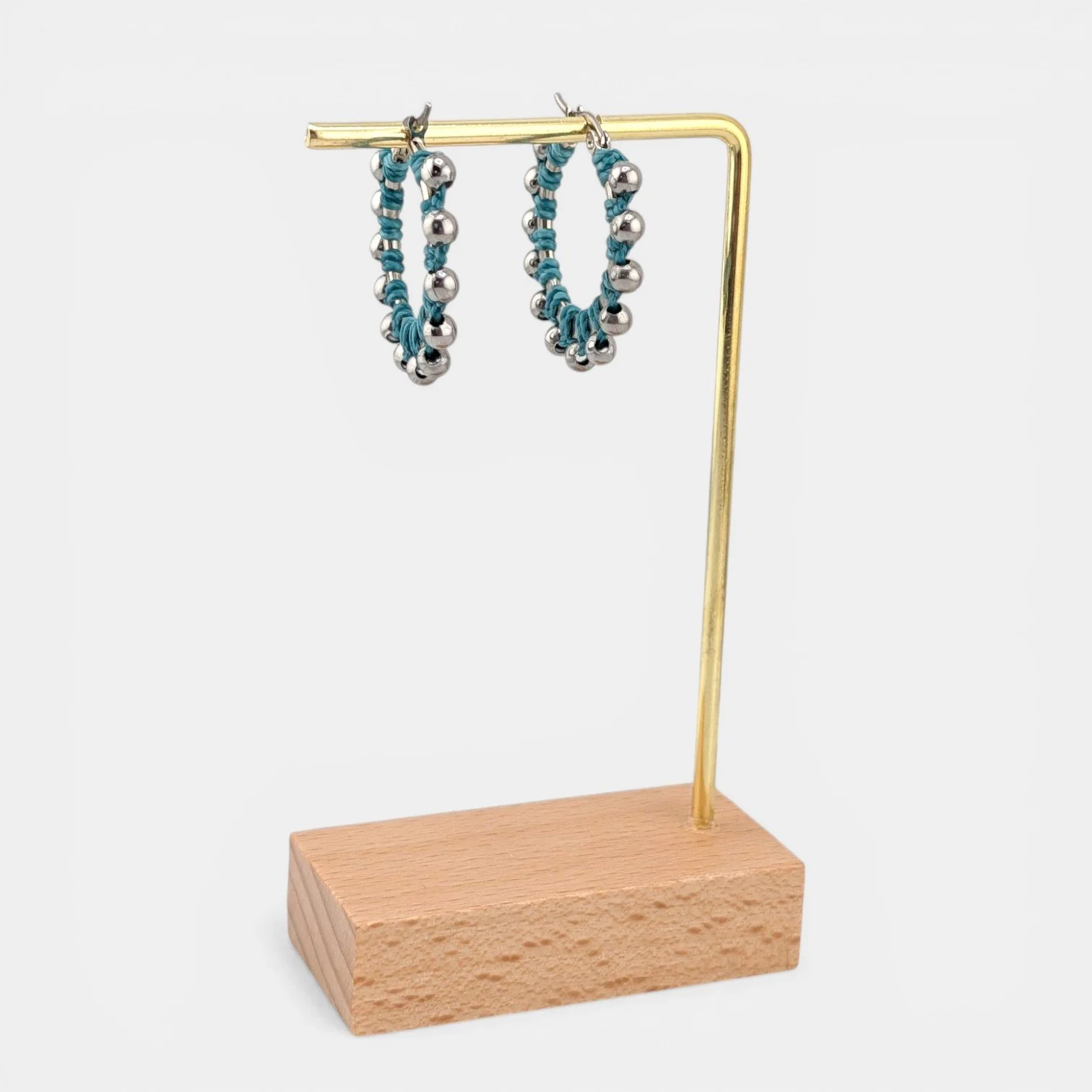 Turquoise beaded macramé stainless steel hoop earrings in silver, 30 mm drop shown on earring display stand