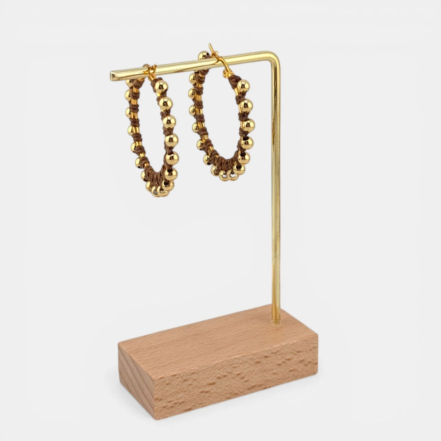 golden brown beaded macramé stainless steel hoop earrings in gold, 40 mm drop shown on earring display stand