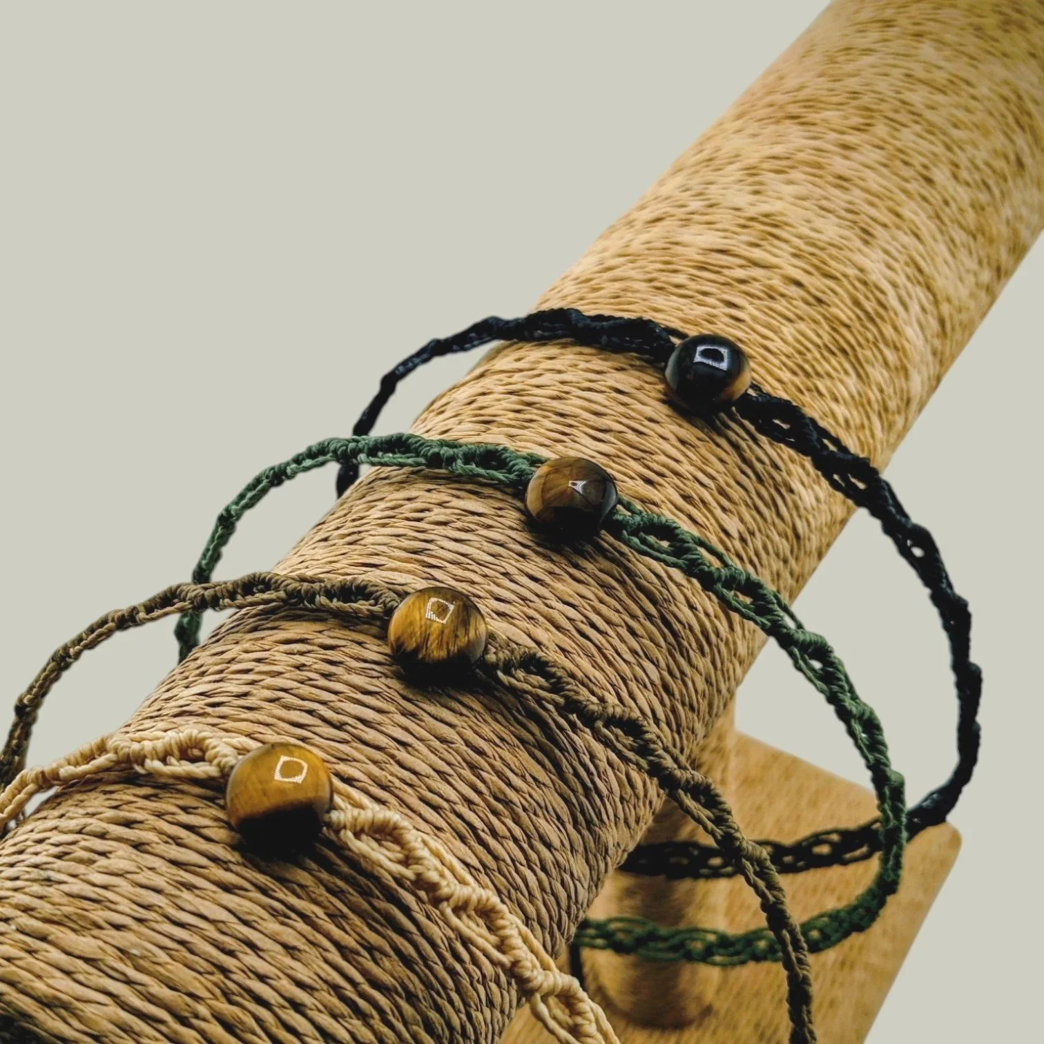 Tiger eye macrame woven choker necklace displayed on jewelry t-bar with four cord color options