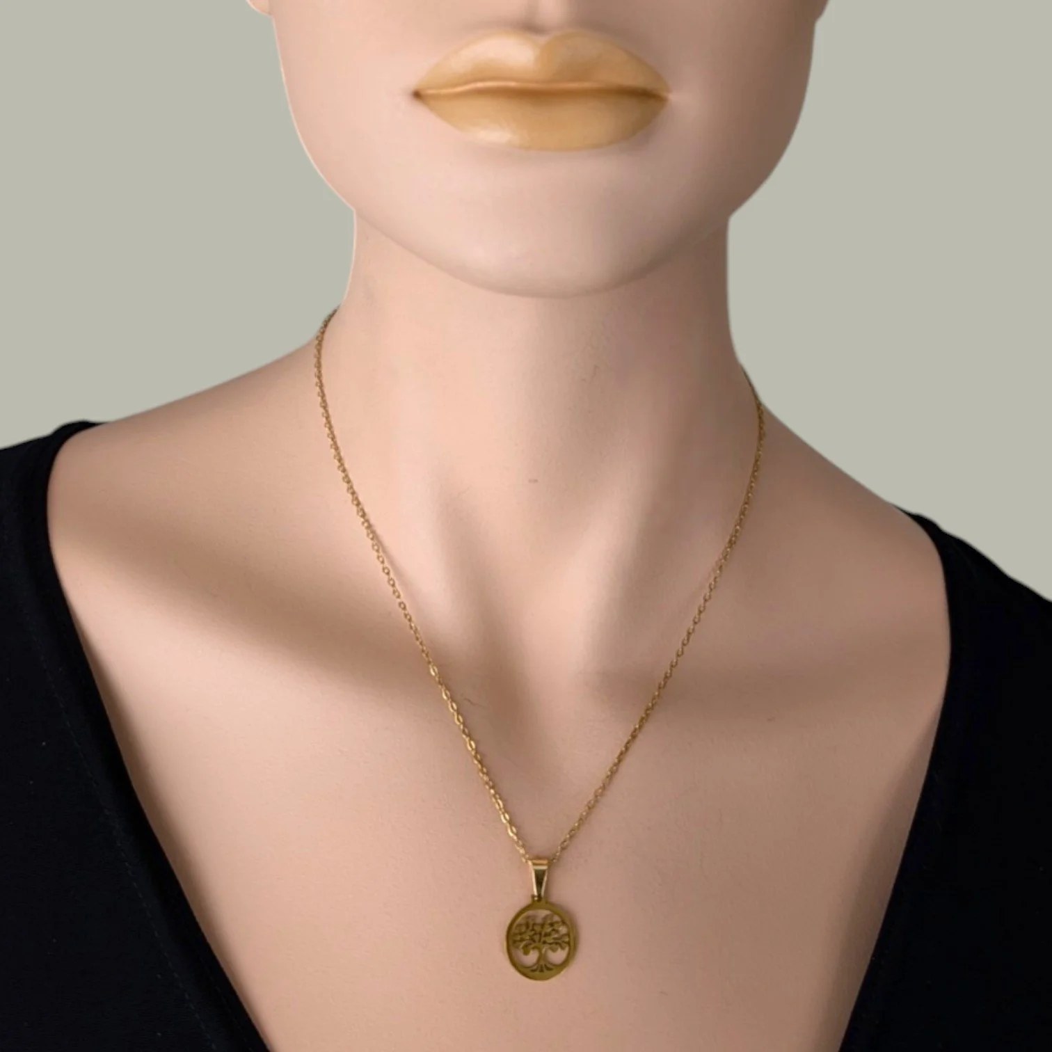 tree of life gold stainless steel necklace on mannequin bust close-up