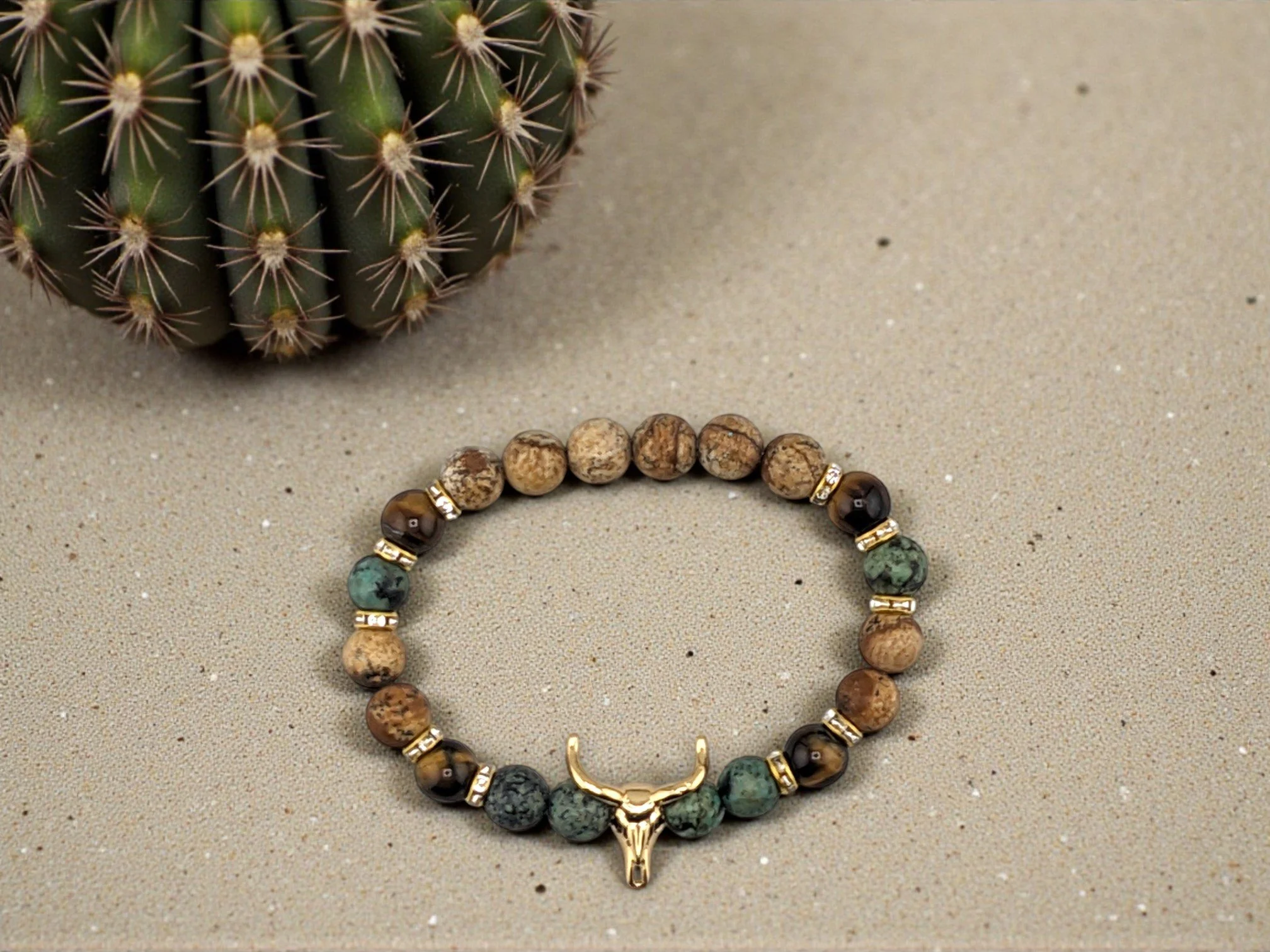 Earth tone gemstones with a bull skull charm separated by rhinestone spacer beads