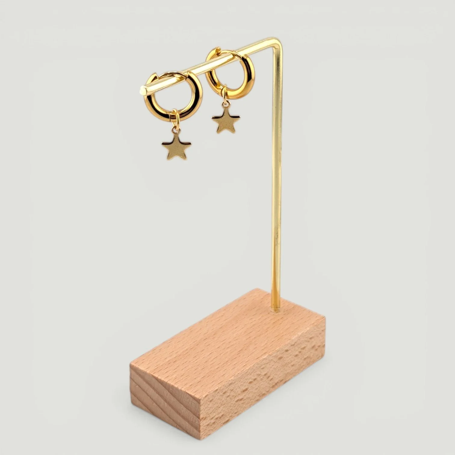 star stainless steel huggie hoop earrings, gold, on earring stand, drop view