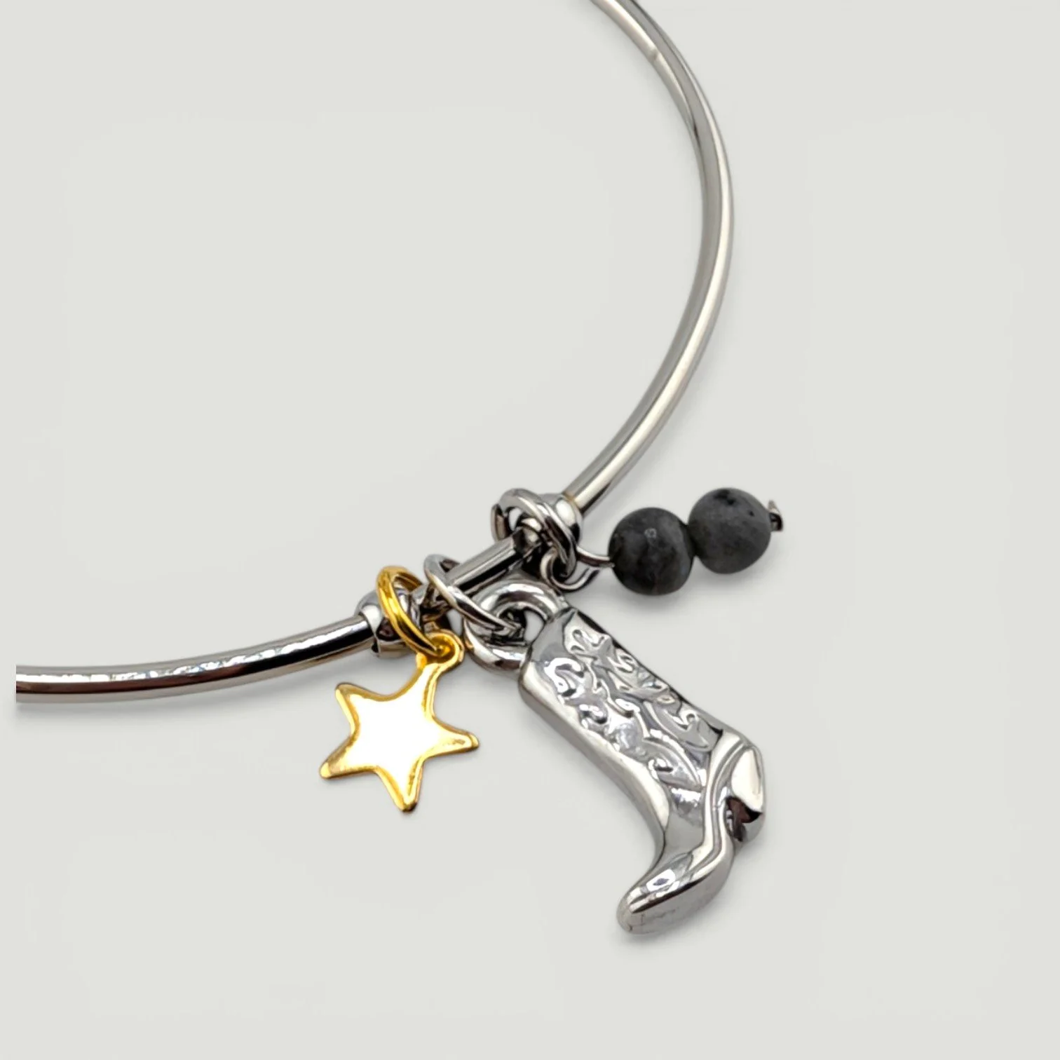 Silver cowboy boot stainless steel bangle bracelet with star and gemstone accents, close-up