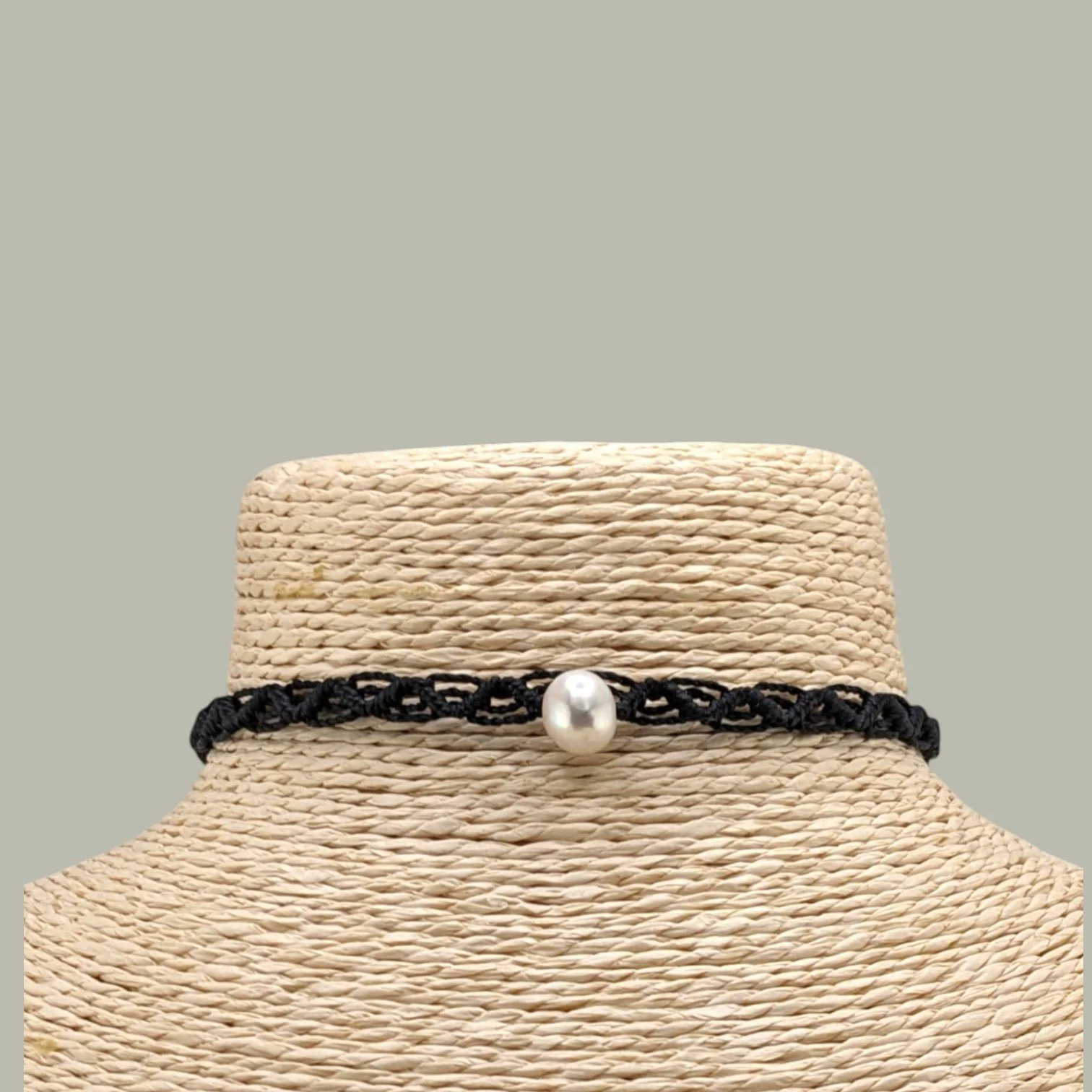 close-uo view of the freshwater pearl woven macrame choker displayed on a jewelry bust