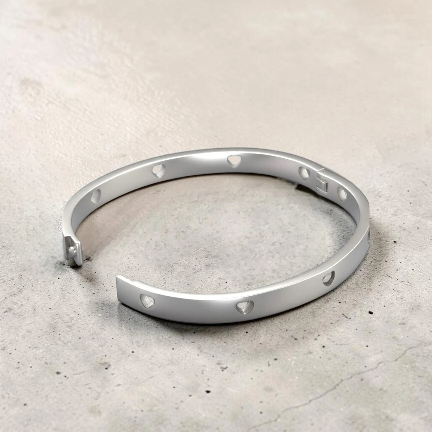 Silver hollow heart stainless steel bangle bracelet, slightly open angled view