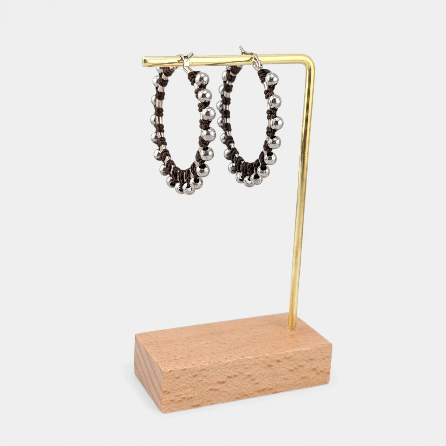 Dark brown beaded macramé stainless steel hoop earrings in silver, 40 mm drop shown on earring display stand