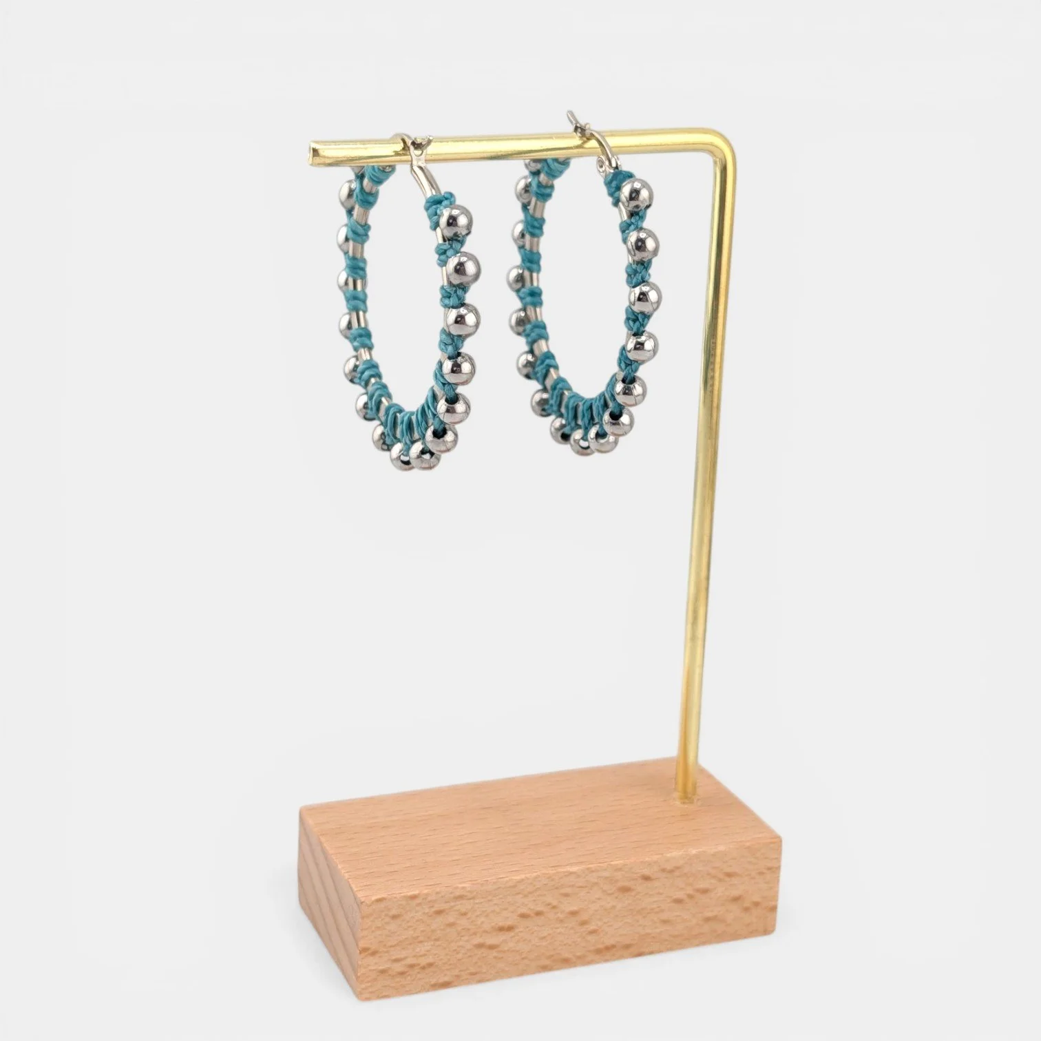 Turquoise beaded macramé stainless steel hoop earrings in silver, 40 mm drop shown on earring display stand