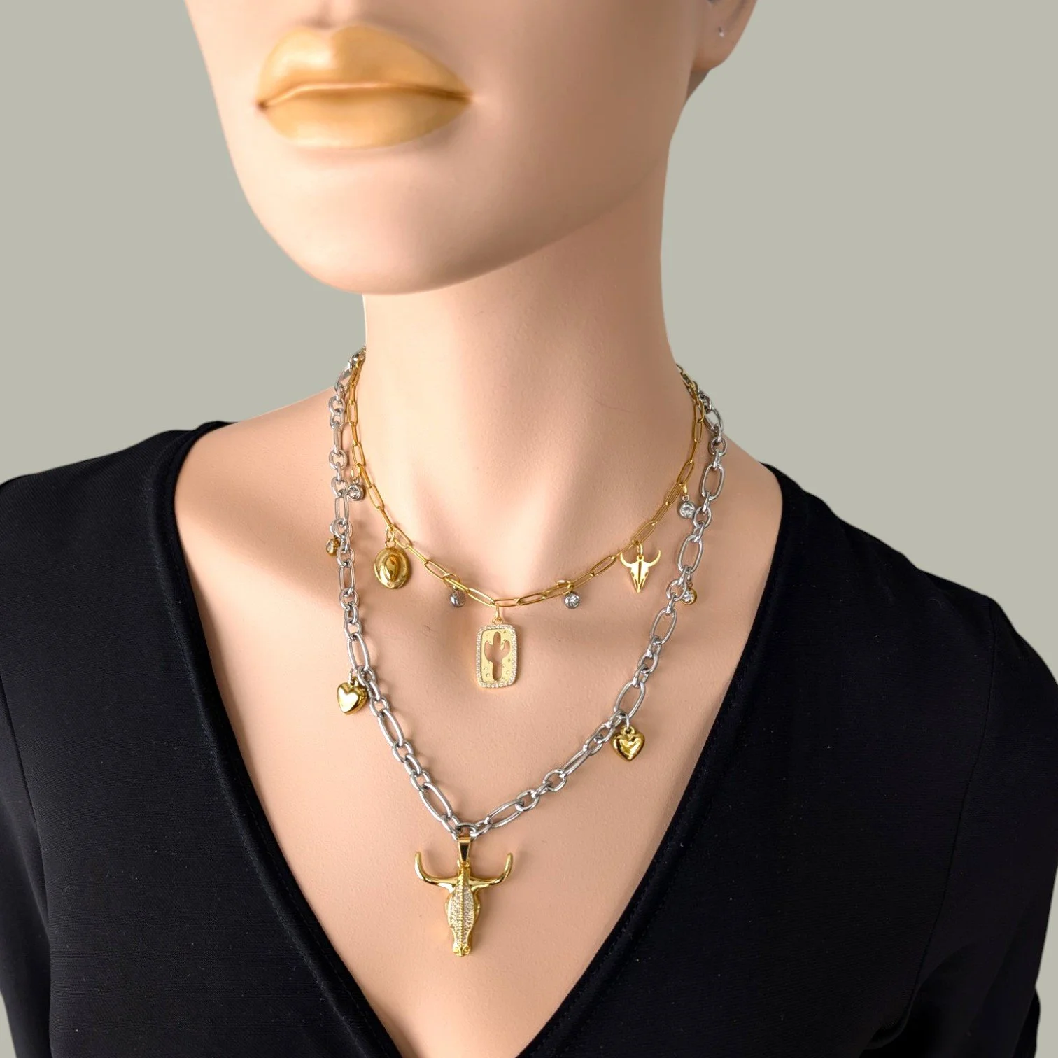 rhinestone bull skull gold stainless steel statement necklace layered with cactus charm necklace on mannequin close up bust view