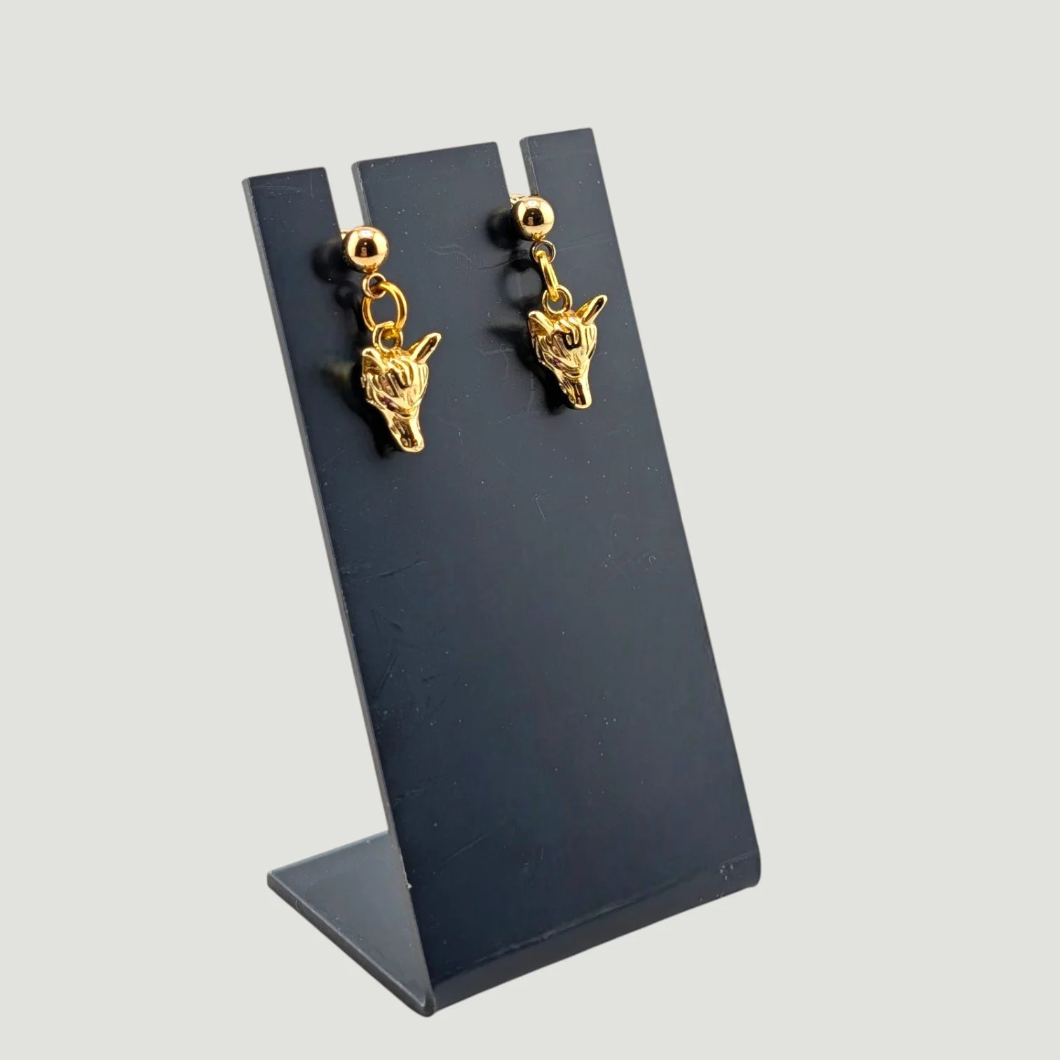 wolf stud drop earrings, gold tone, on earring stand, drop view