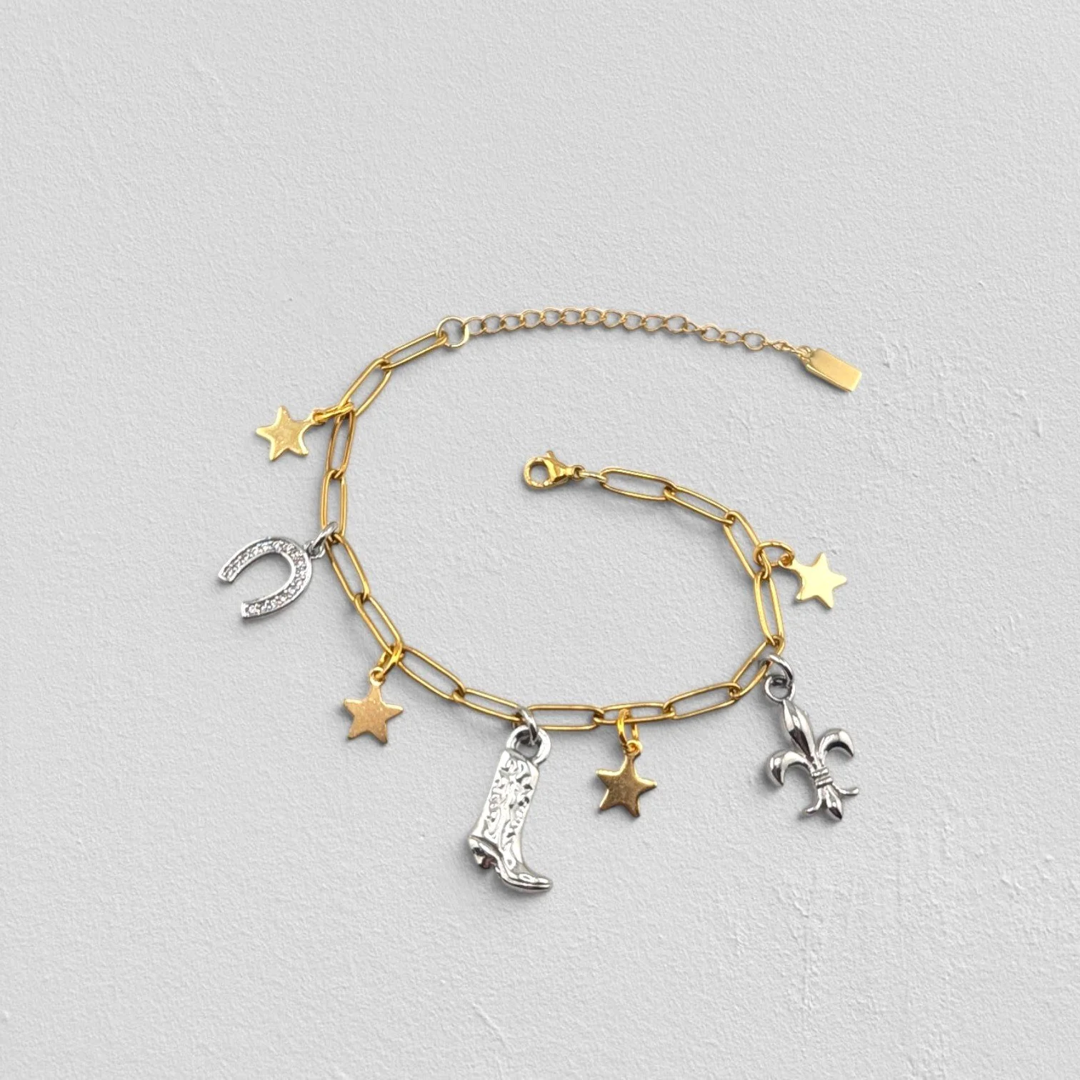 Gold two-tone cowboy boot stainless steel charm bracelet, full flat lay