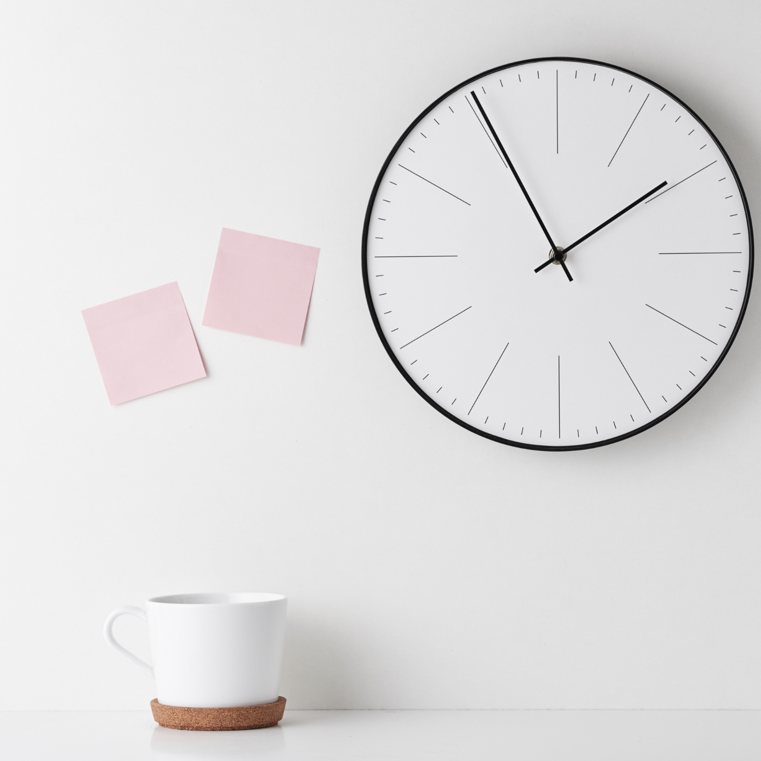 Wanduhr zeigt 07:55, zwei rosa Notizzettel an Wand,