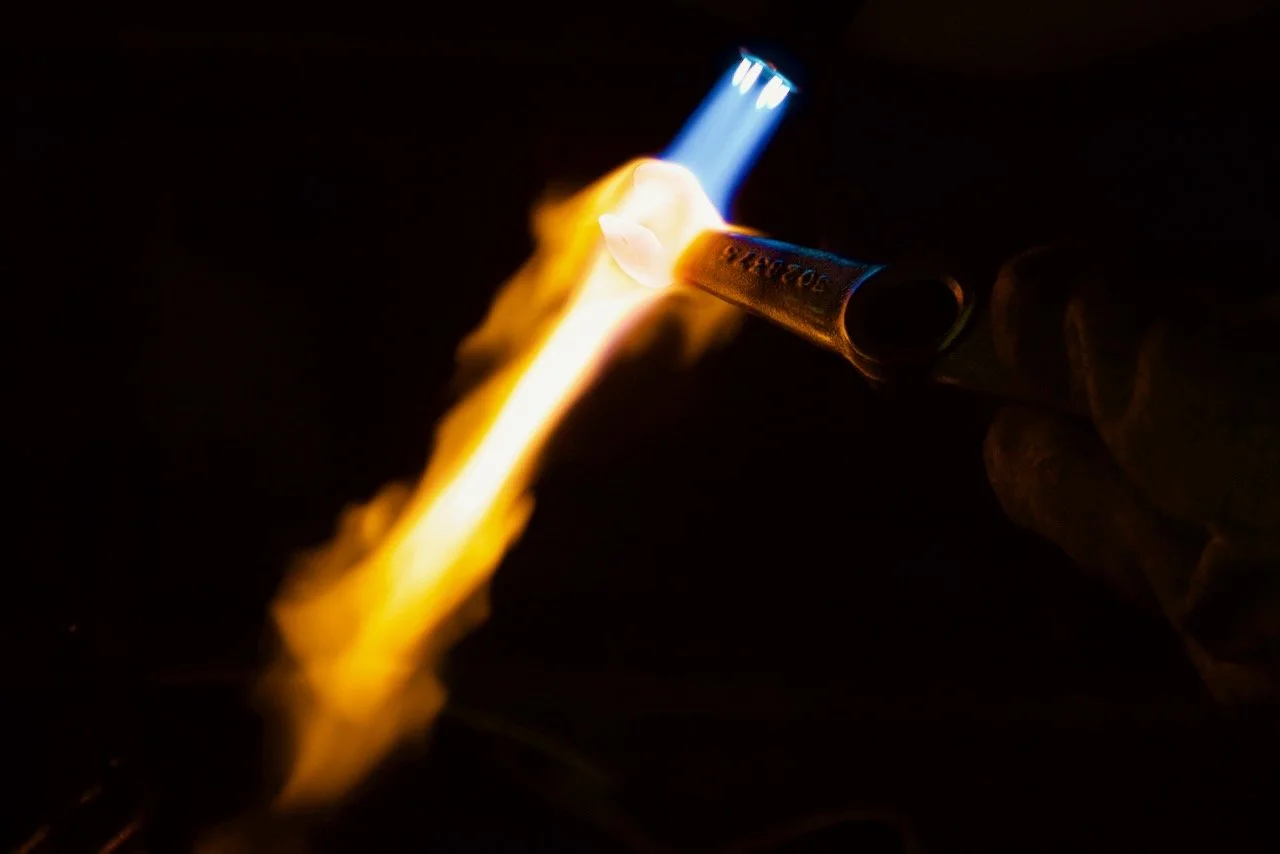 An intense flame is hitting an industrial metal part