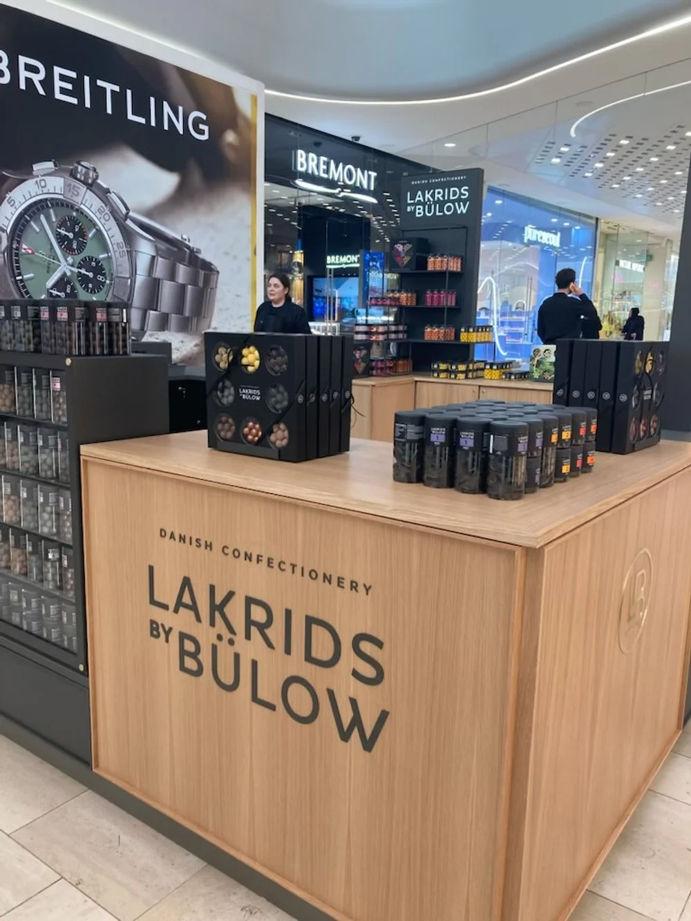 Display kiosk for Danish confectionery Lakrids by Bülow in a shopping mall, with shelves of candy and promotional signs in the background.