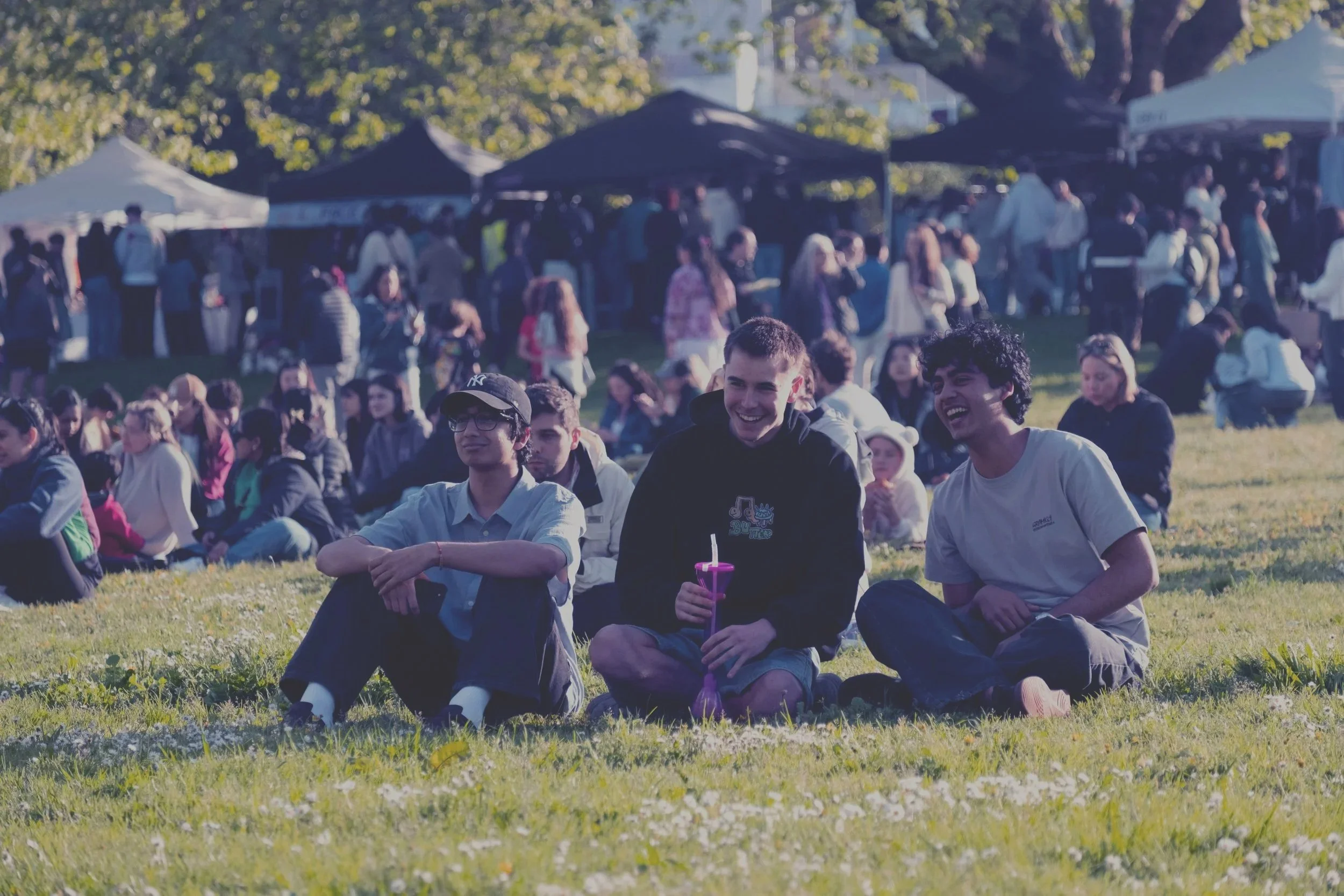 People sitting on grass during Open Circle Markets.