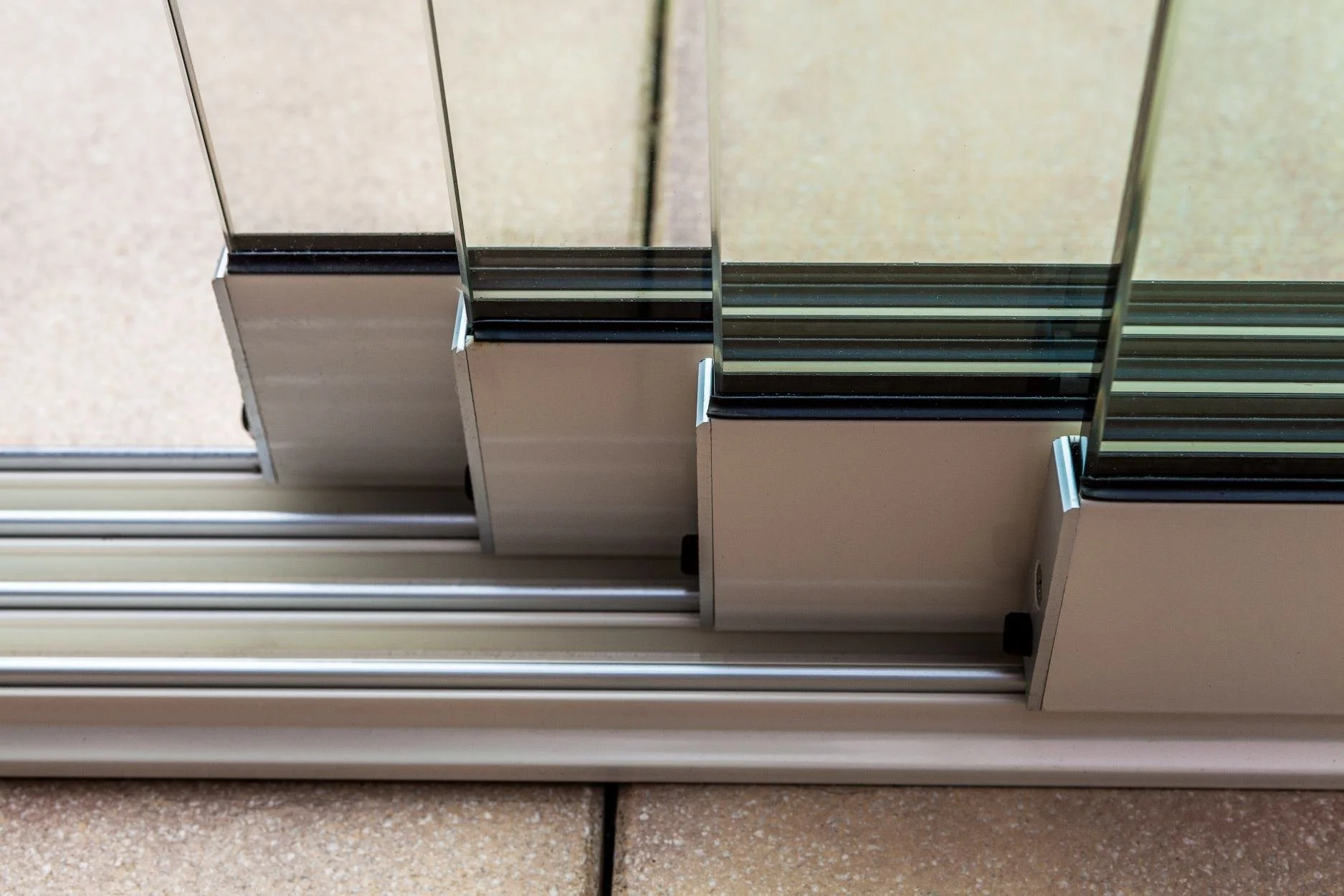 Close-up of a glass sliding door track with glass panels and metal frame.