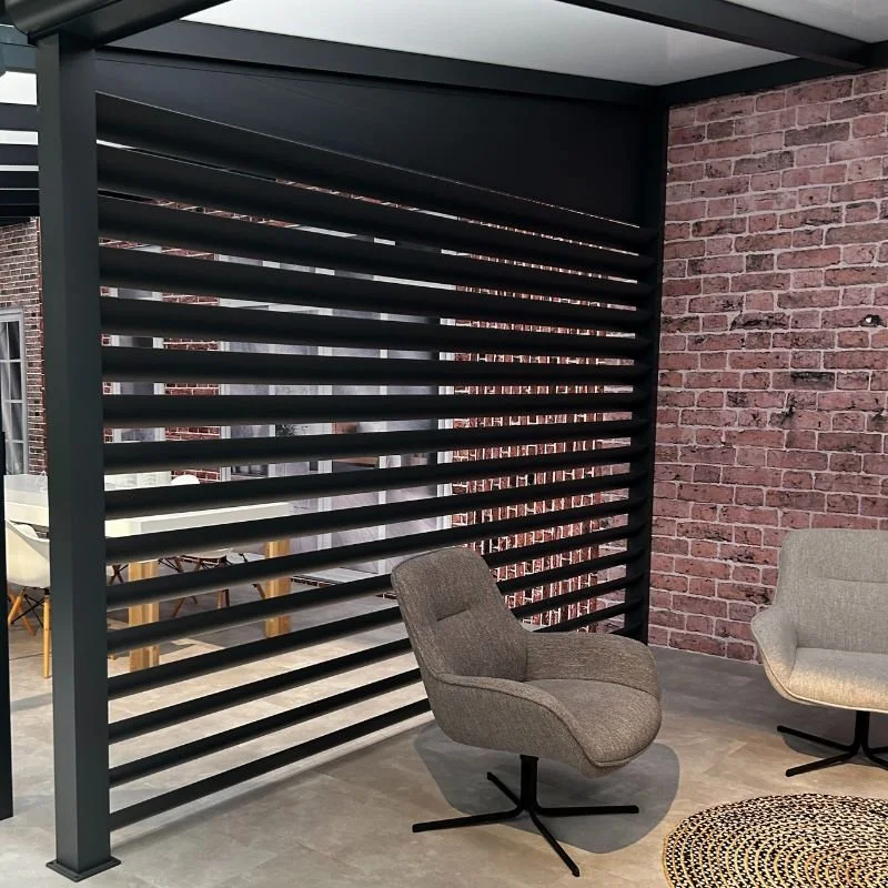 Modern indoor space with brick wall, black slatted room divider, and two mid-century style chairs.