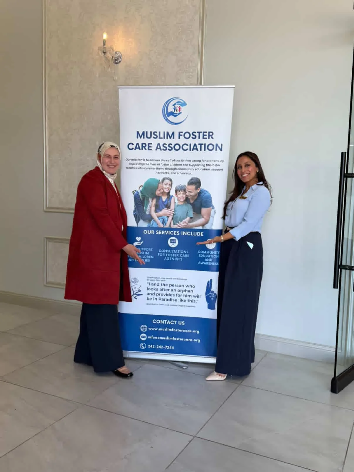 Miraj Events owner with a client beside a banner for the Muslim Foster Care Association, smiling and pointing at it. The banner displays the organization's logo, services, and contact information.