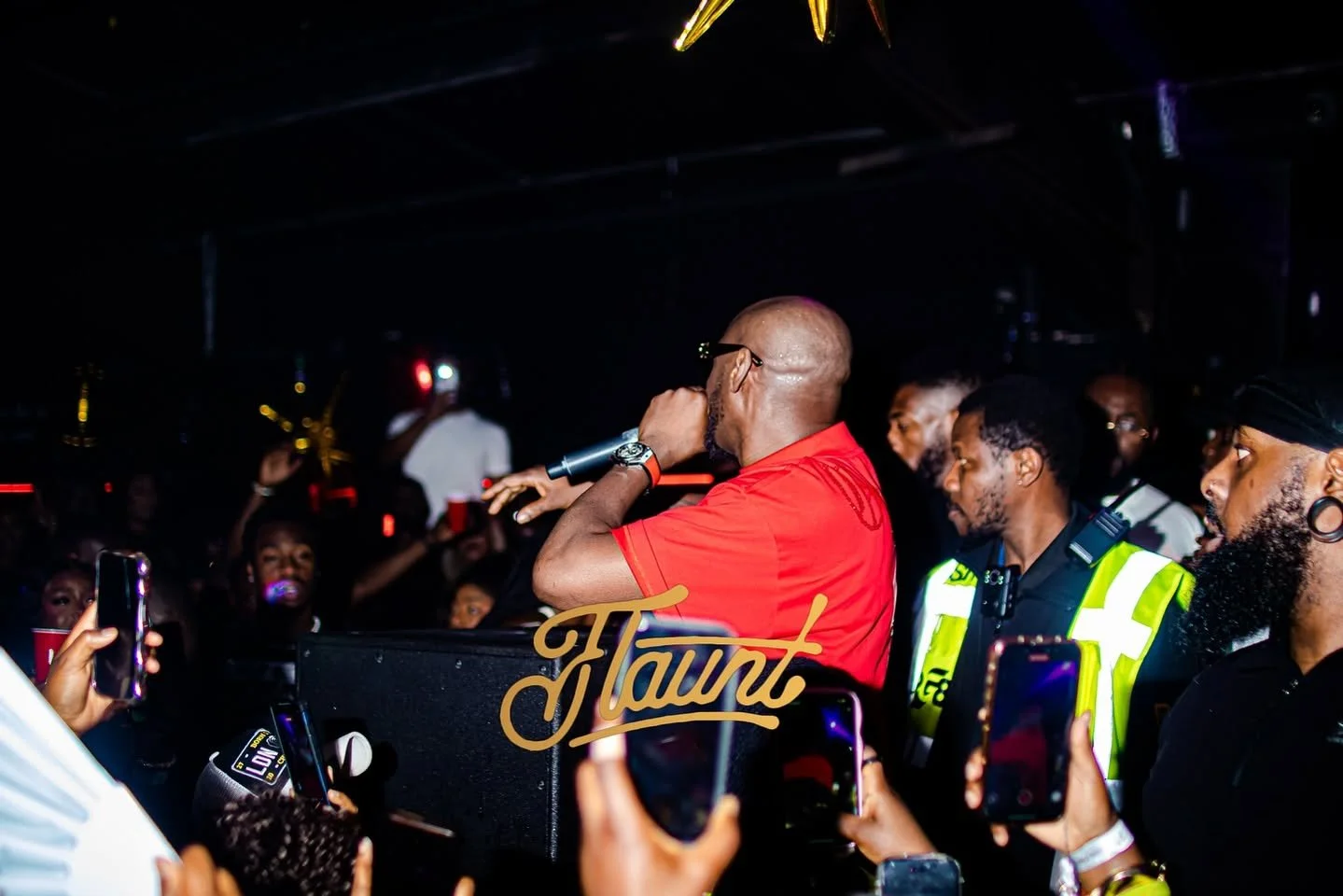 2face Idibia live on stage at concert in Birmingham, England. Security personnel on standby with an energetic crowd.