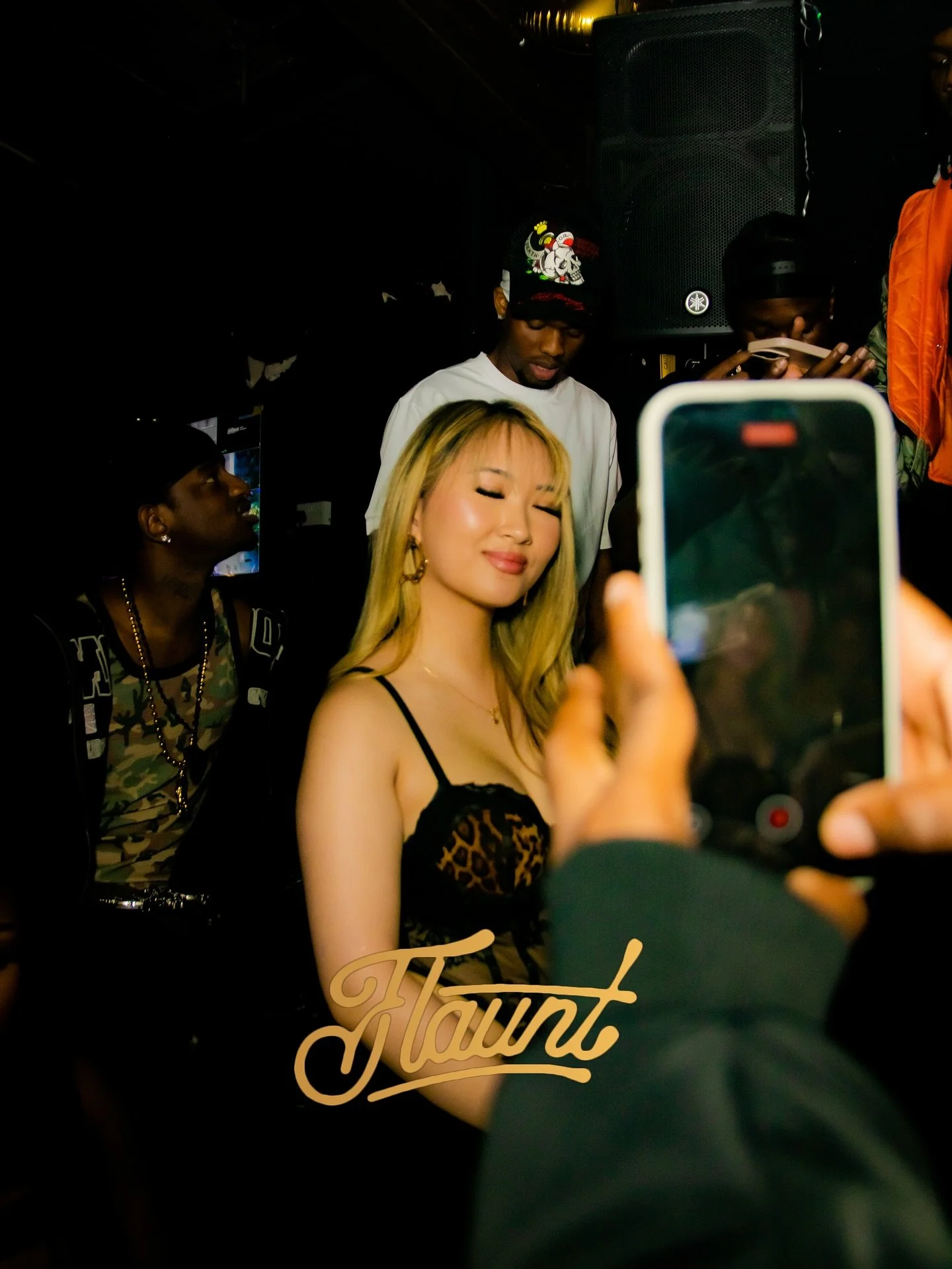 A woman with blonde hair and a black leopard-print top poses at flaunt