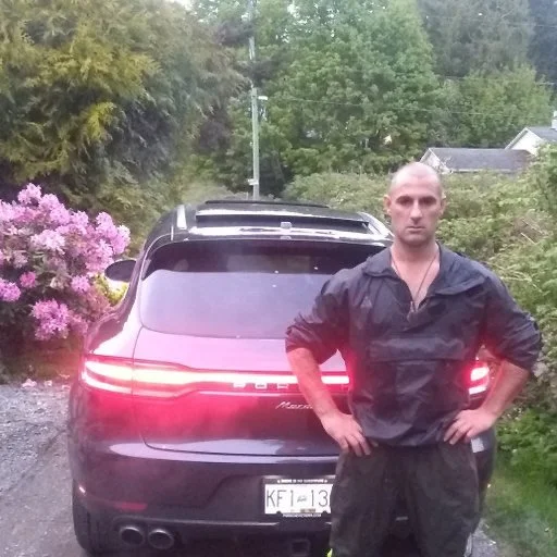 Founder of DarkCell Syndicate standing in front of a black SUV outdoors, representing leadership behind a private biotech discovery platform.