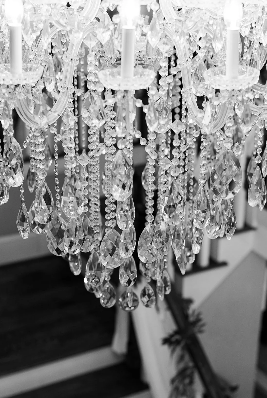 A detailed close-up of a crystal chandelier with hanging crystal drops and decorative beads.